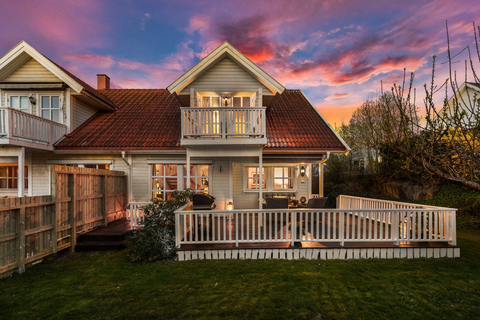 Innbydende fasade med stor, vestvendt terrasse og balkong, perfekt for å nyte solfylte ettermiddager. Velstelte uteområder skaper en hyggelig ramme rundt boligen. Galleribilde