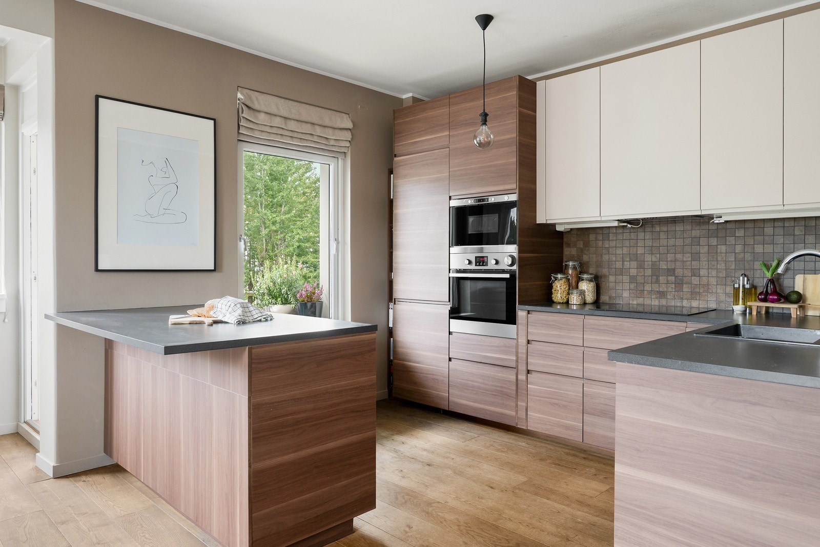 Praktisk og innbydende kjøkken i pen løsning til stuen, med god skap- og benkeplass. Galleribilde