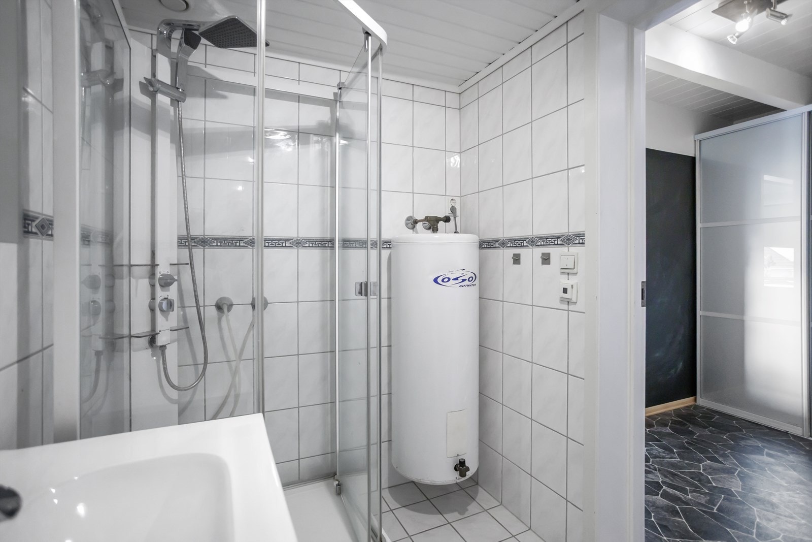 Badet inneholder toalett, dusjkabinett, servant med speil, samt opplegg for vaskemaskin. Galleribilde