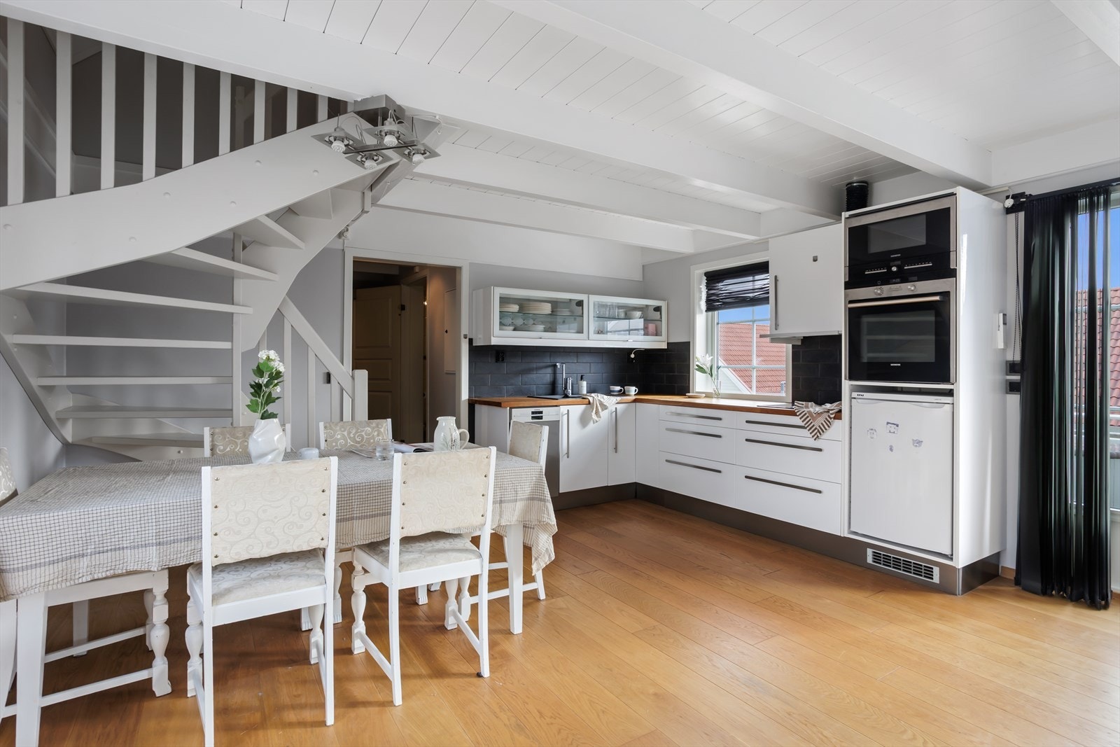 Pent kjøkken med lyse, slette fronter og heltre benkeplate. Galleribilde