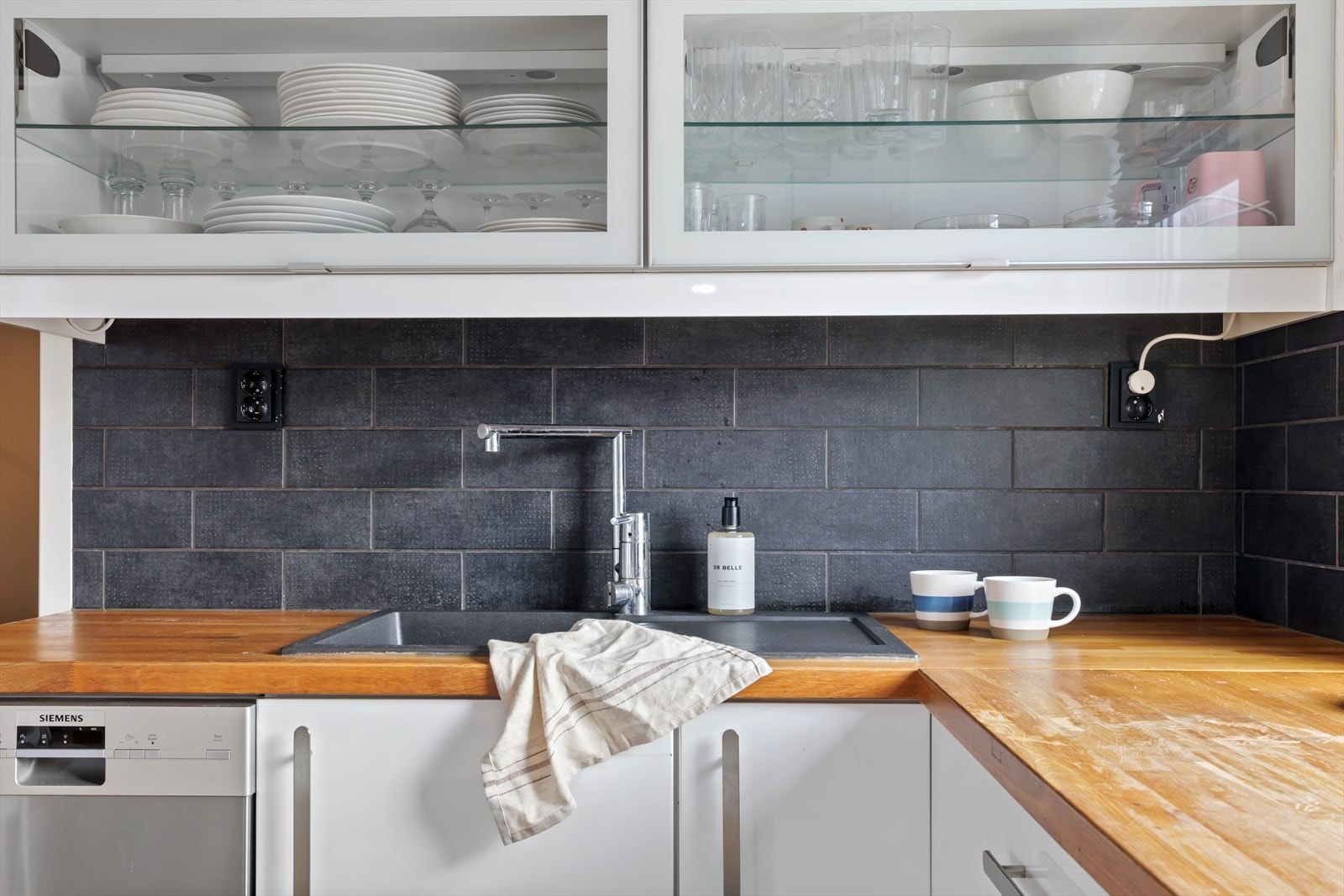 Innredningen byr på praktisk oppbevaringsplass i skap og skuffer. Over benken er det montert fliser. Galleribilde