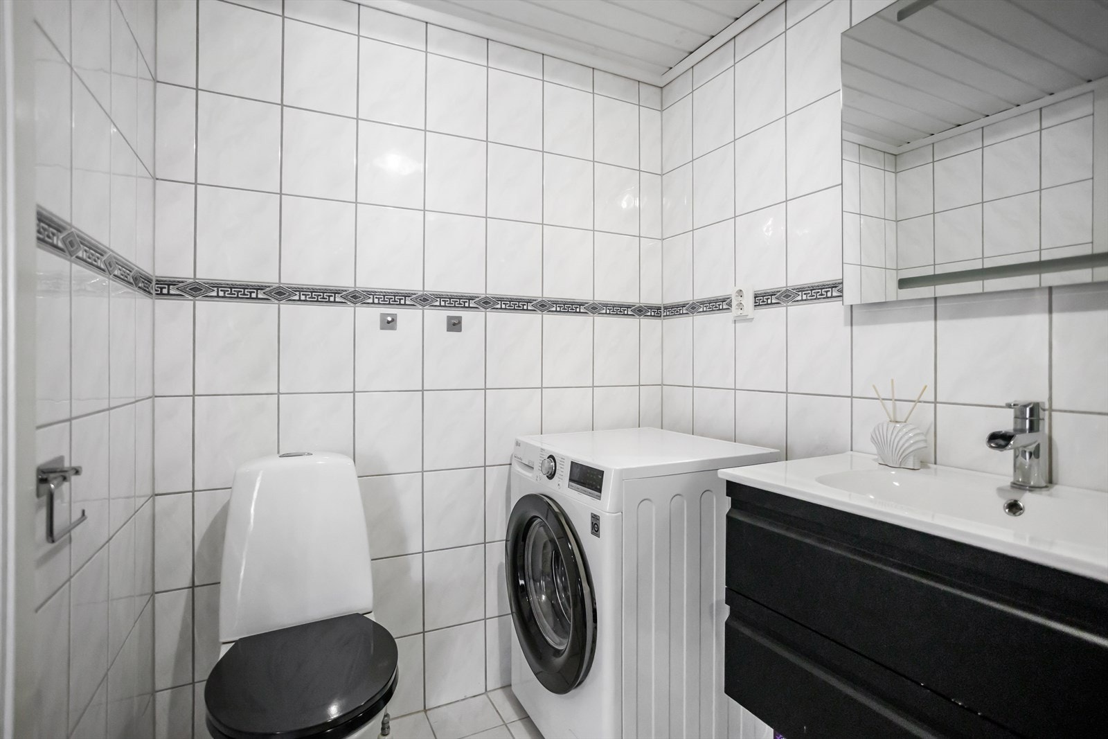 Vegger og gulv er flislagt, og taket har malt panel som gir et lyst og rent uttrykk. Galleribilde