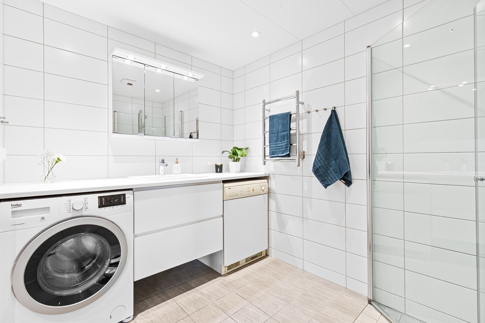 Badet har et tidløst uttrykk med delikate gulvfliser og klassiske, hvite veggfliser. Det er vannbåren gulvvarme og downlights i himlingen. Galleribilde