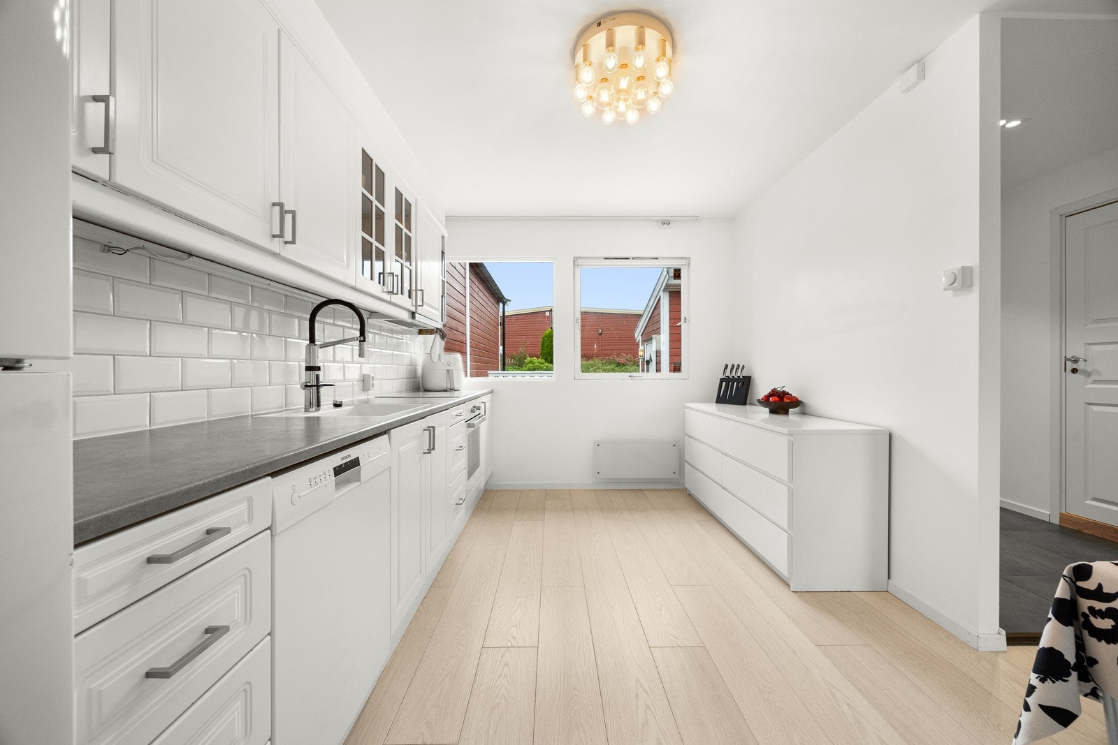 nnredningen har vitrineskap, hvite, profilerte fronter og en laminert benkeplate. Galleribilde