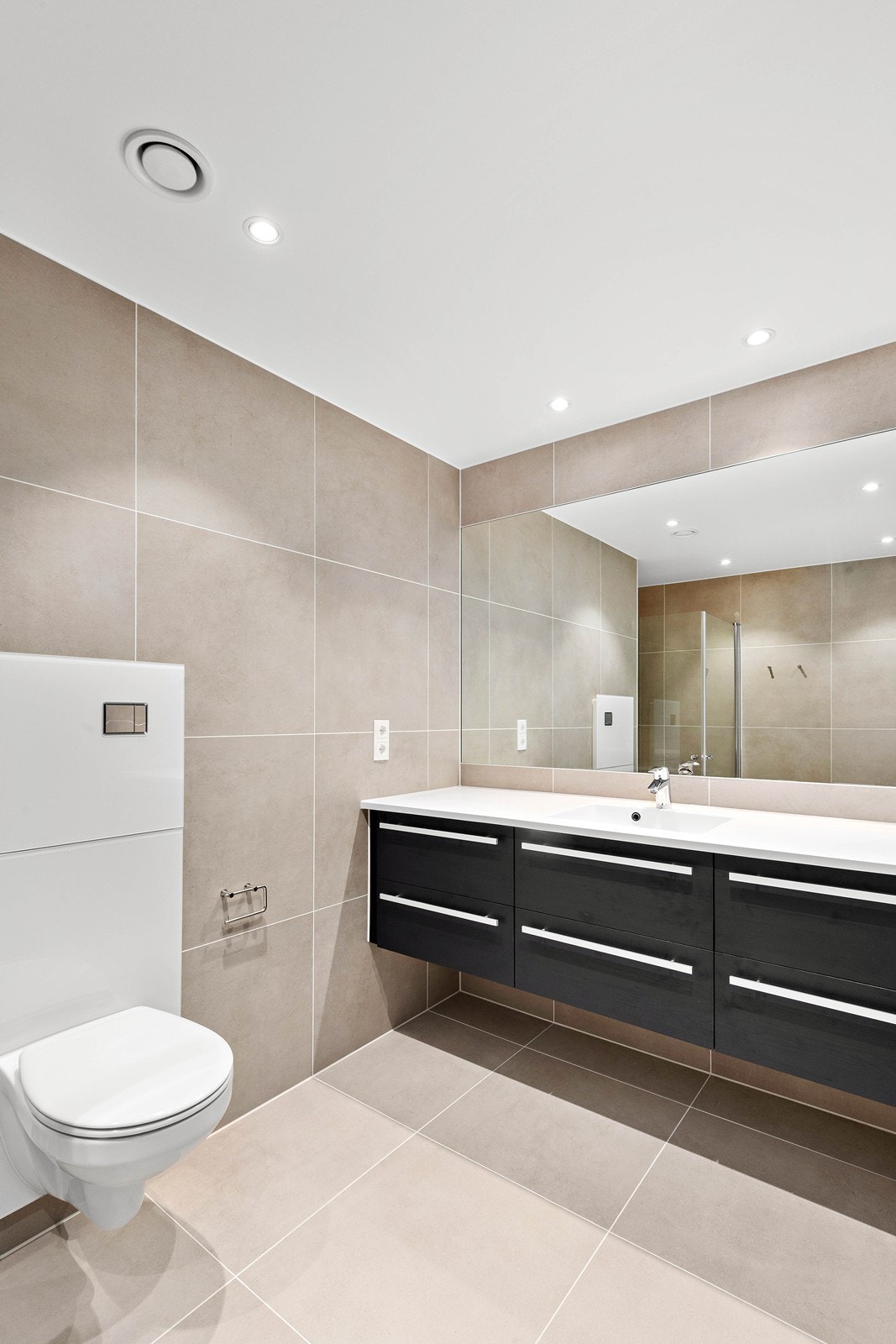 Vegghengt klosett, oppgraderte baderomsmøbler og 60*60 fliser i tidløse fargetoner. Galleribilde