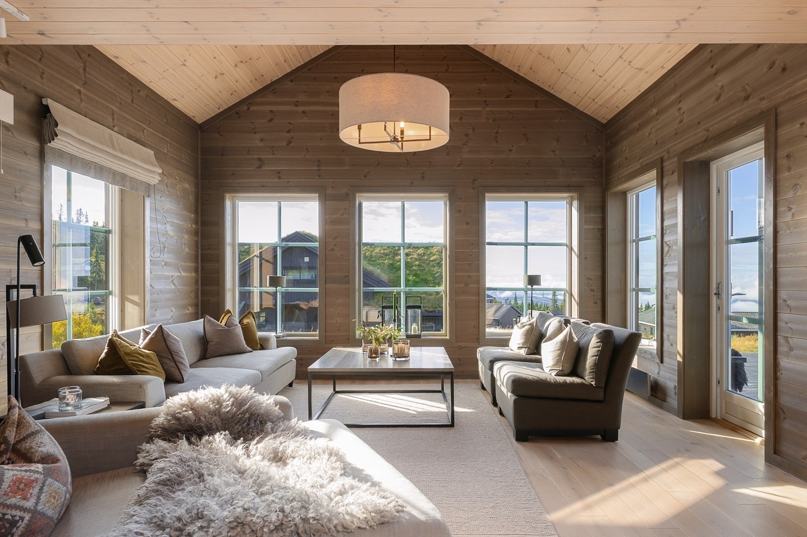 Innbydende og romslig stue der en fin kombinasjon av god takhøyde og store vindusflater gir en meget god romfølelse. Galleribilde