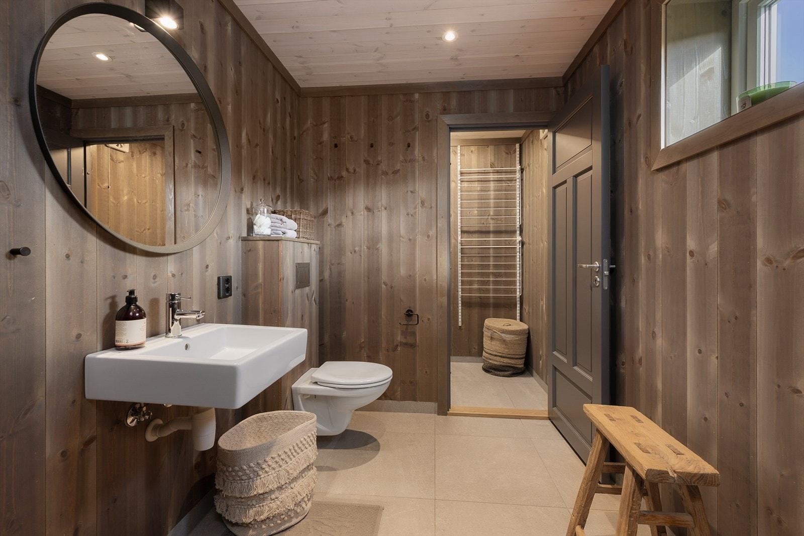 Hovedbadet fremstår som romslig og innbydende, med flislagt gulv og varmekabler. Servant og vegghengt WC. Direkte adkomst til vaskerom fra badet. Galleribilde