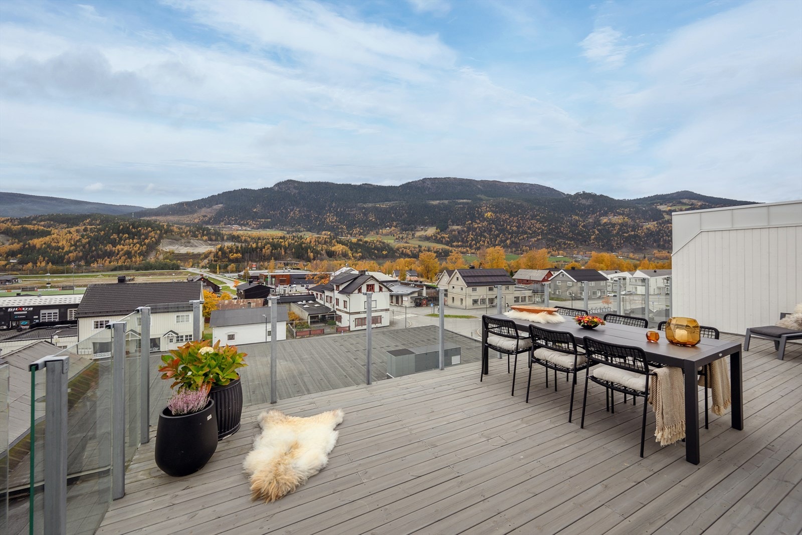 Veranda har plass til flere sittegrupper og har glassrekkverk Galleribilde