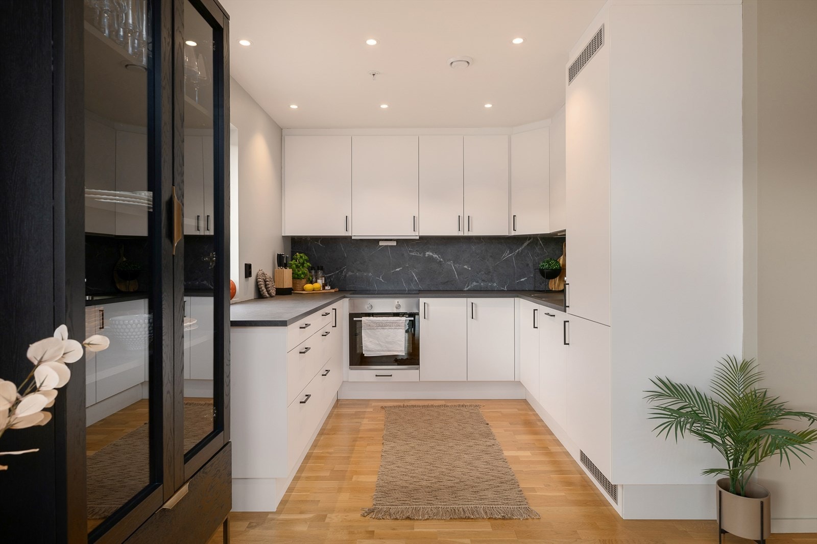 Kjøkkenet leveres med integrerte hvitevarer og har synlige detaljer i sort utførelse. Galleribilde