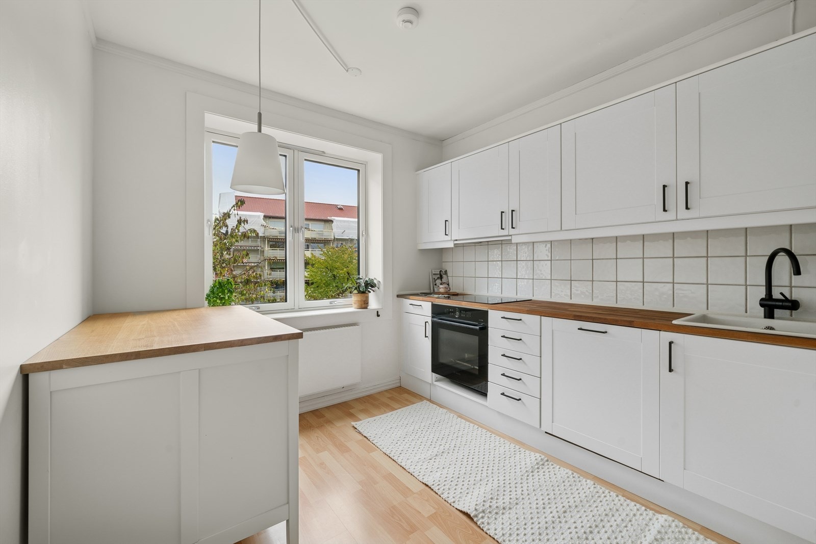 Videre fra entreen kommer man inn i leilighetens innbydende kjøkken. Galleribilde