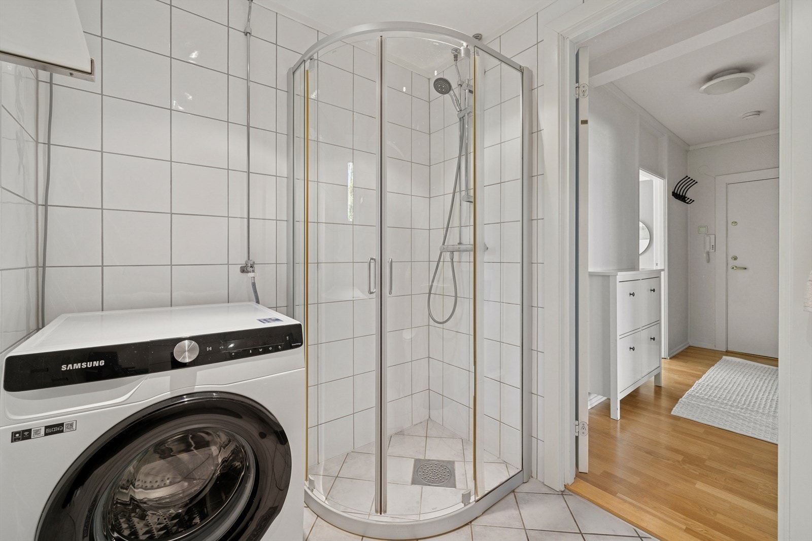 Her finner du dusjnisje med innfellbare glassdører og opplegg for vaskemaskin. Galleribilde