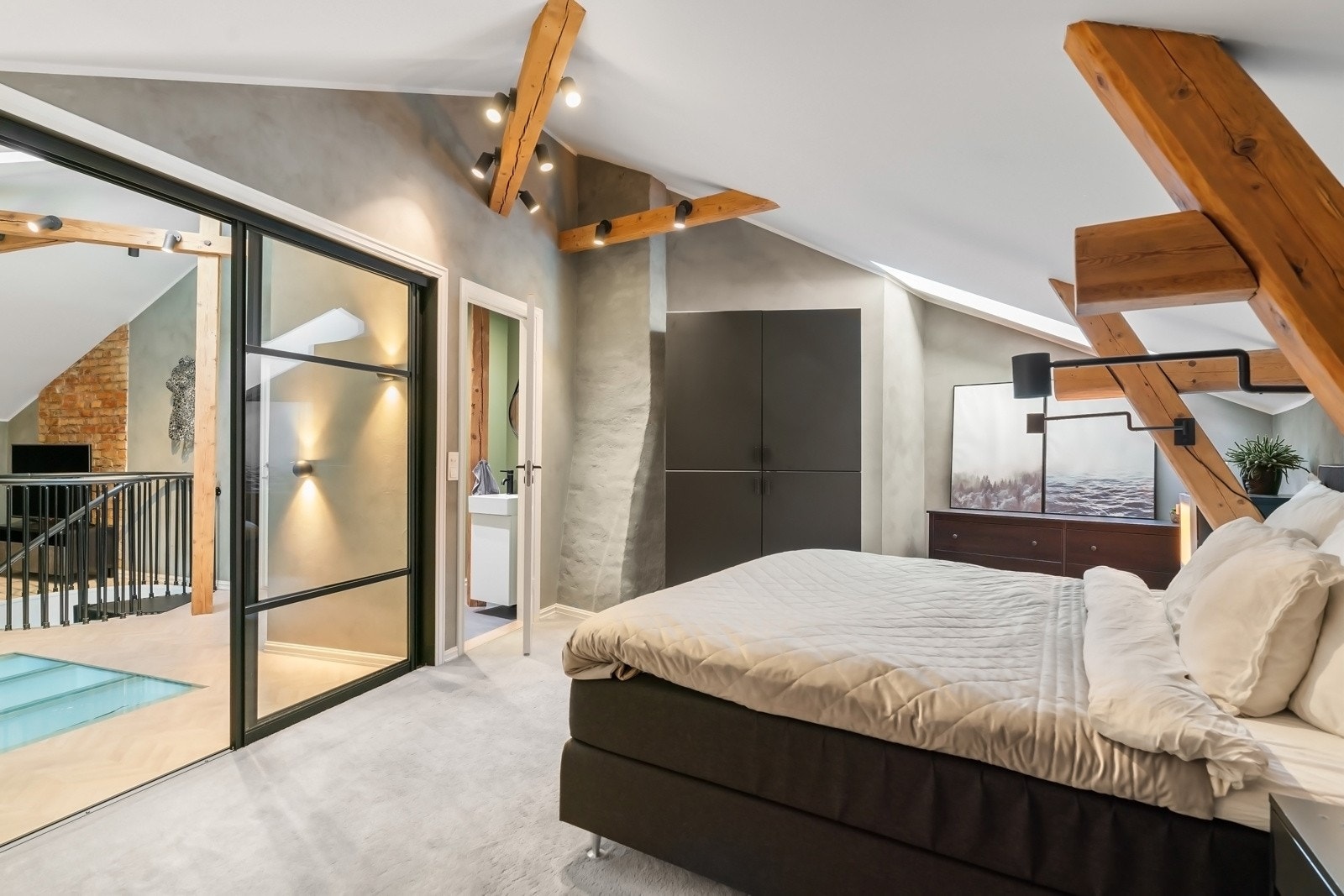 Rommet har adkomst via en stilfull glassdør fra loftstuen Galleribilde