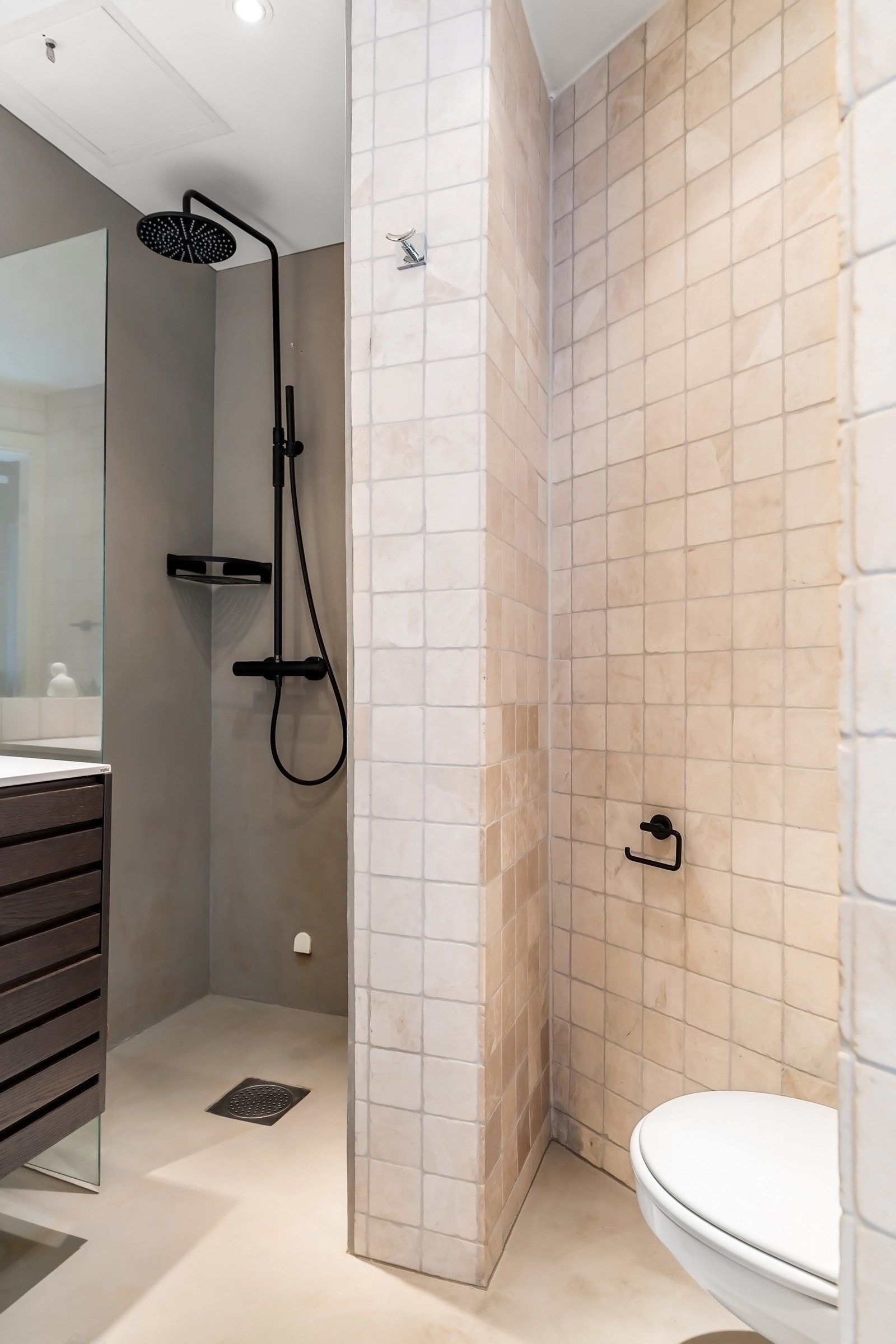 Innredningen består av en skuffeseksjon med mørke heltre frontert, samt et stort speil. Vegghengt toalett og dusjhjørnet med regnfallsdusj Galleribilde