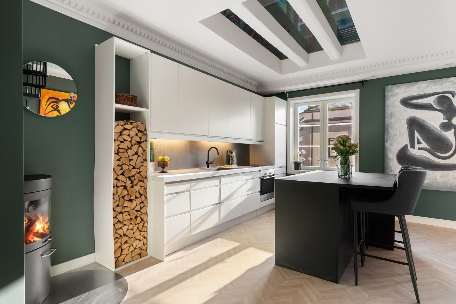 Kjøkkenet ligger i åpen løsning med spisestuen og har et stilrent, moderne design med gode benkeflater, kjøkkenøy og rikelig oppbevaringsplass Galleribilde