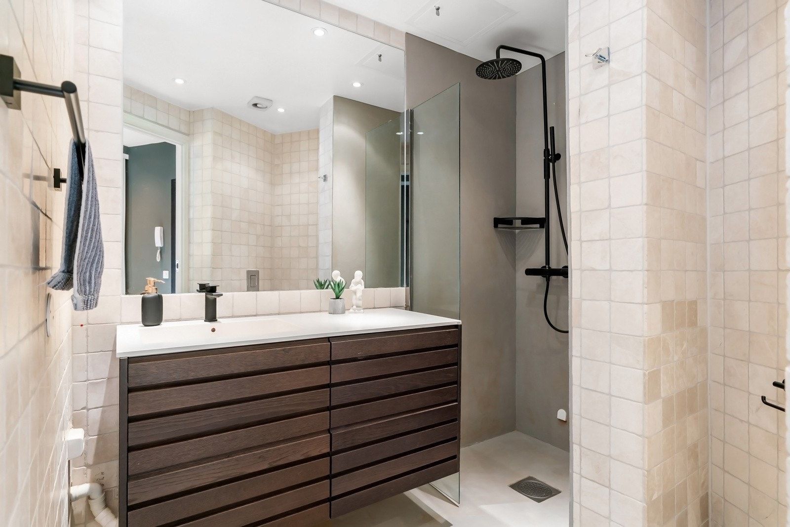 Badet ble pusset opp i 2013 og har en kombinasjon av lys microsement og sandfargede fliser på veggene. Gulvet er belagt med matchende microsement og har varmekabler Galleribilde