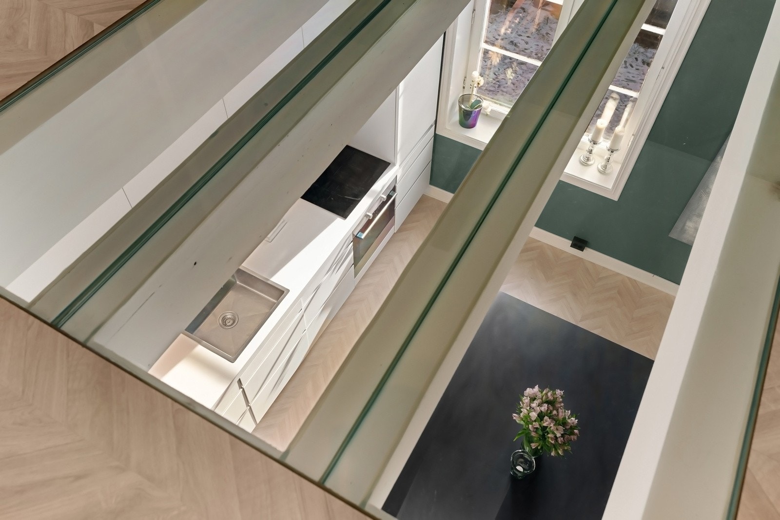 Glassflatene i kjøkkentaket sørger for at naturlig lys fra etasjen under slipper inn, noe som gir en åpen og luftig romfølelse Galleribilde