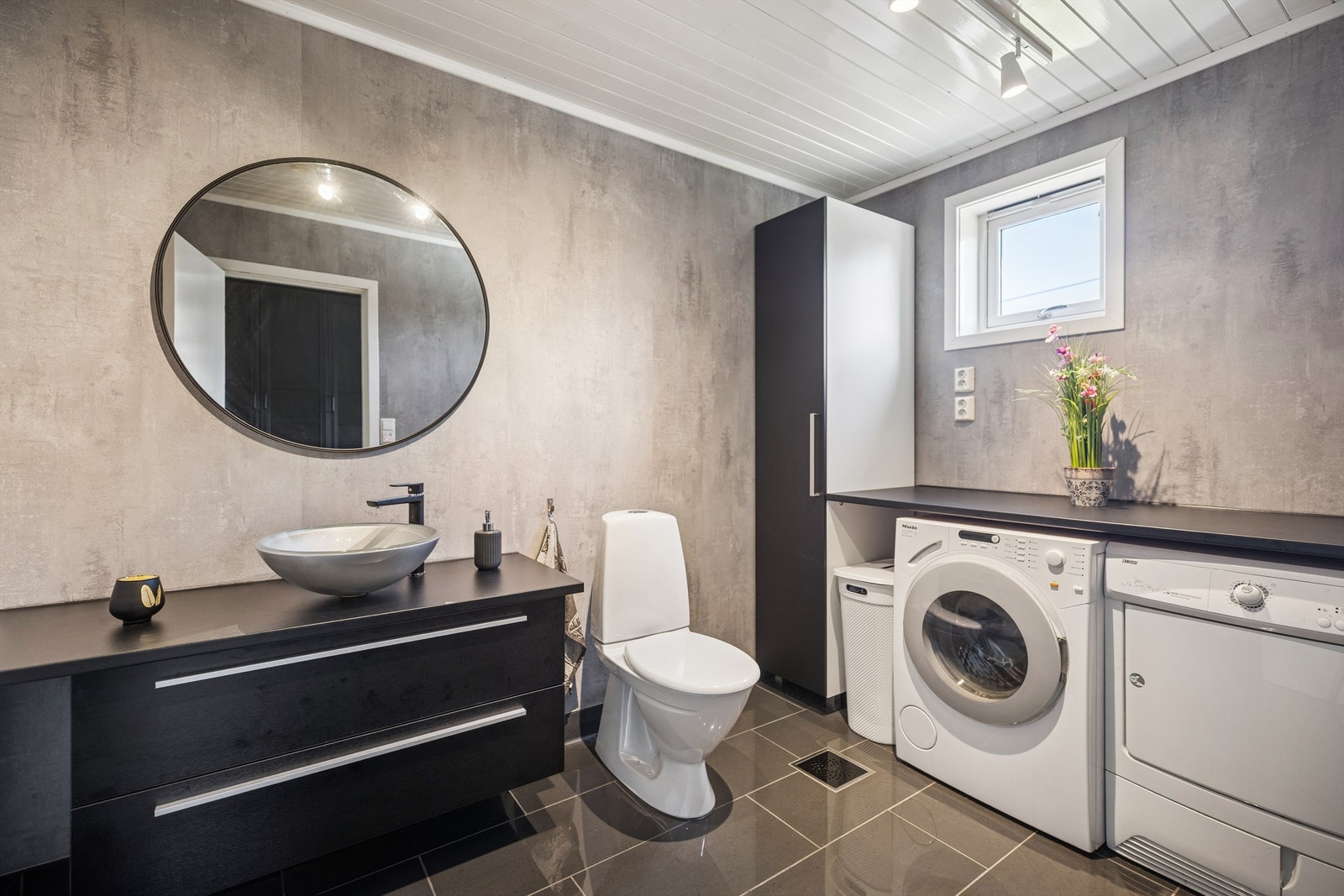 Praktisk og pent vaskerom i 1. etasje med servantinnredning, toalett og opplegg for vaskemaskin og tørketrommel. Galleribilde