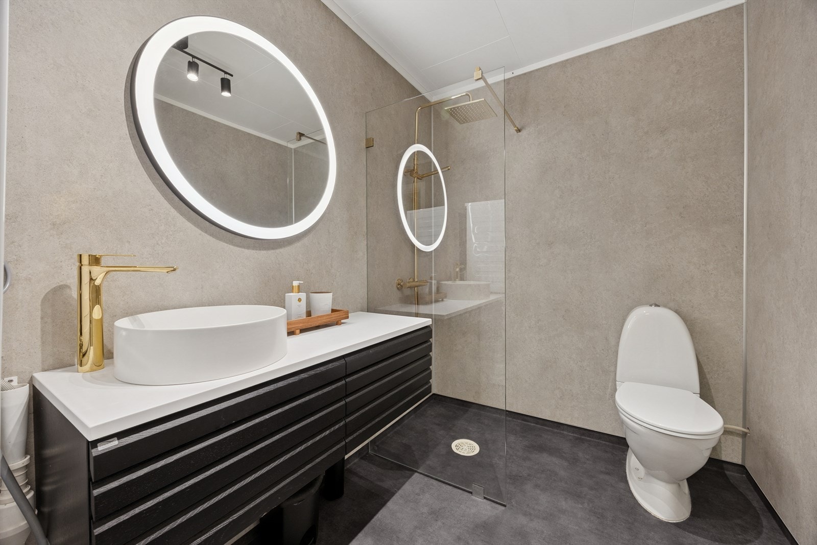 Baderommet har baderomsplater på veggene, og på gulvet finner du vinylbelegg. Galleribilde