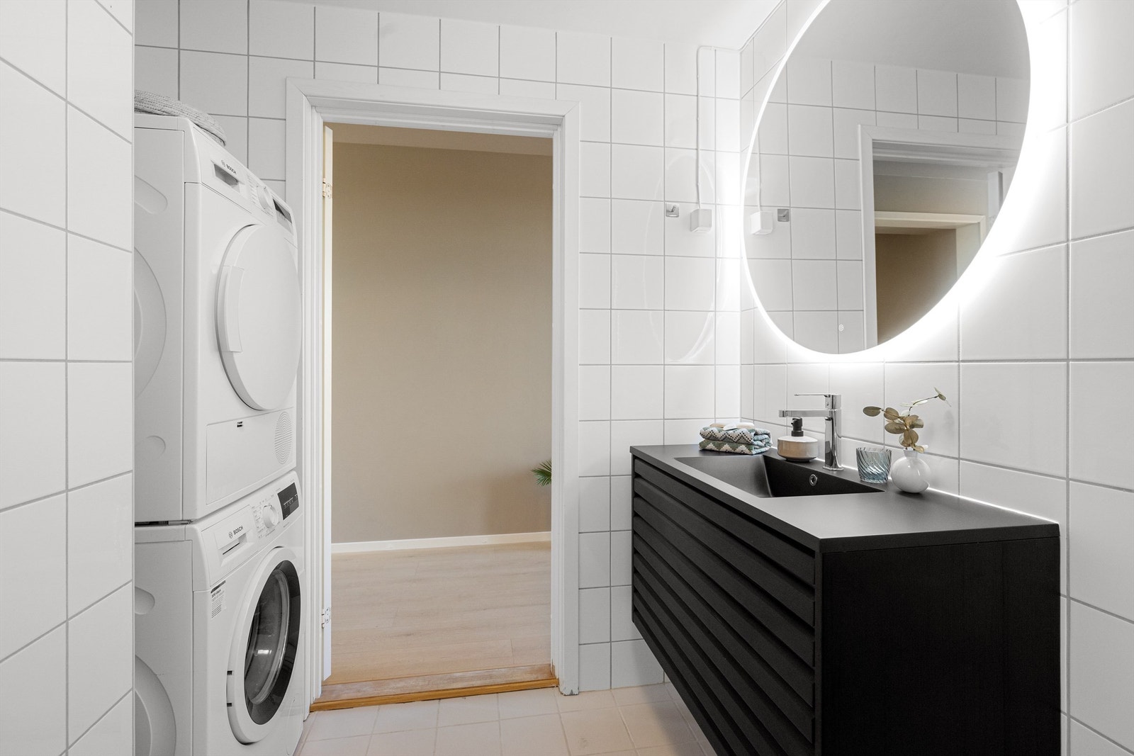Praktisk opplegg for vaskemaskin og tørketrommel. Servantskap med god lagringsplass og speil med integrert belysning gir et rent og moderne uttrykk. Galleribilde