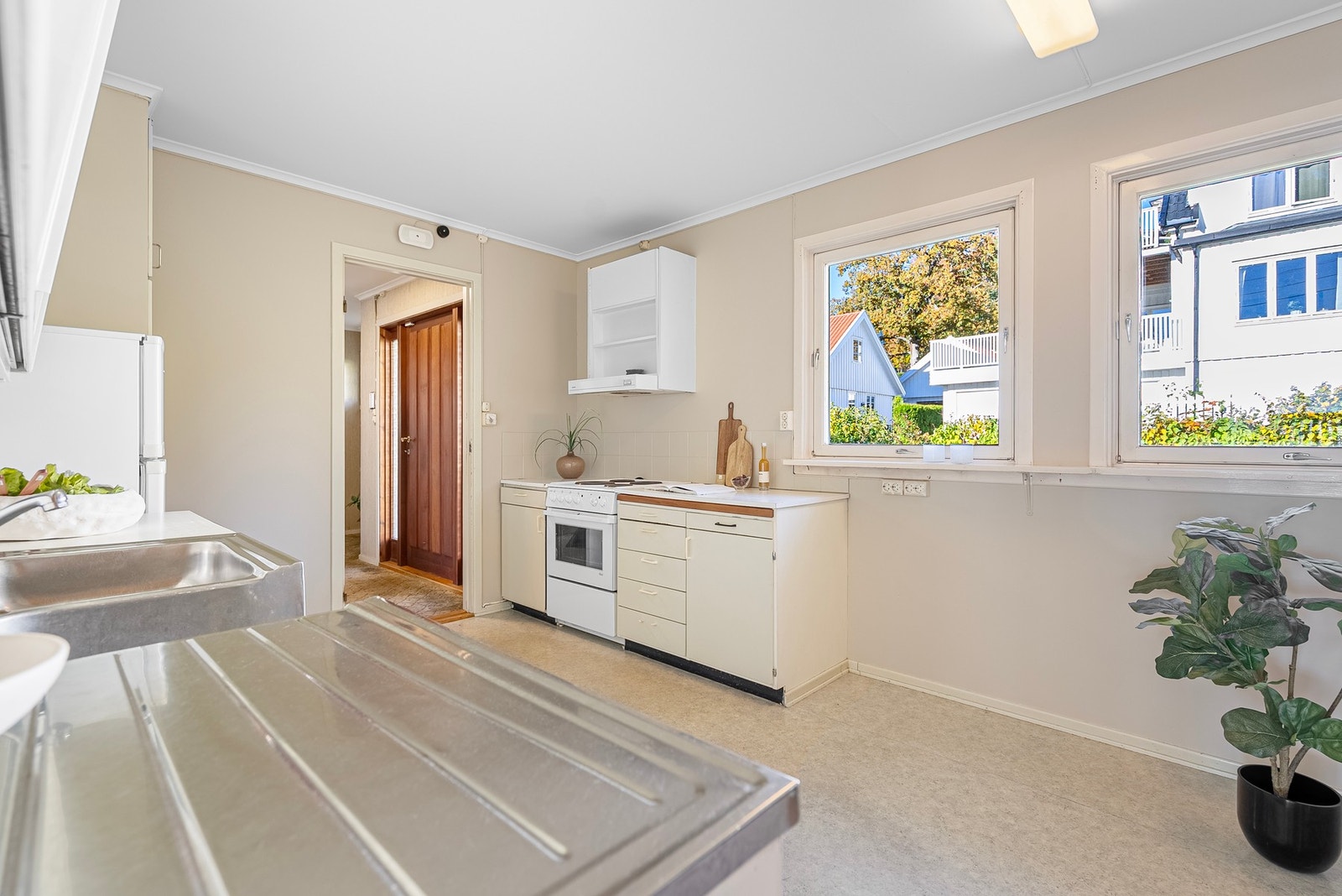 Eldre kjøkkeninnredning med glatte fronter og benkeplate av laminat. Plass for frittstående hvitevarer Galleribilde