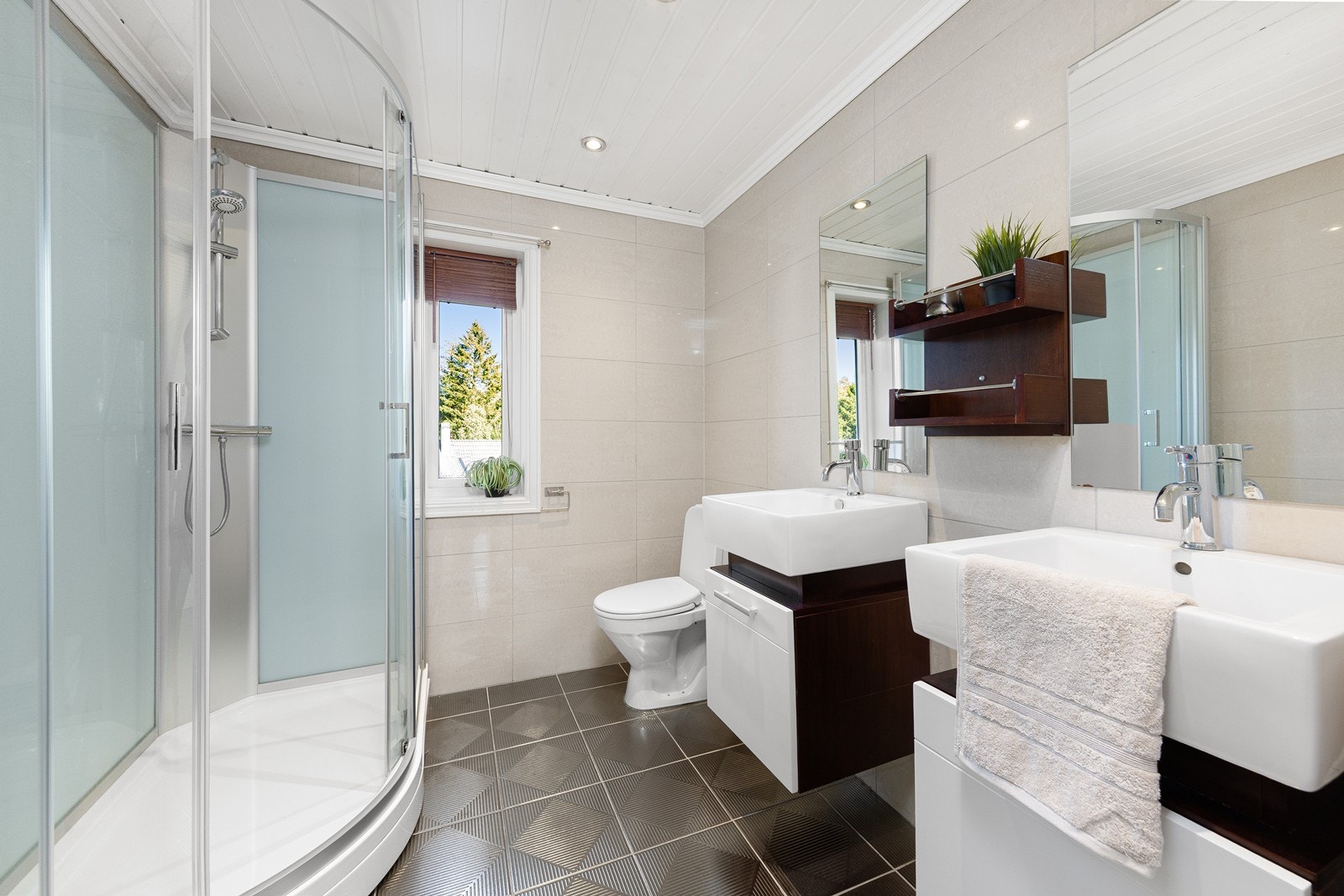 Badet i 1. etasje er innredet med toalett, dusjkabinett og 2 servanter med innredning og speil. Galleribilde