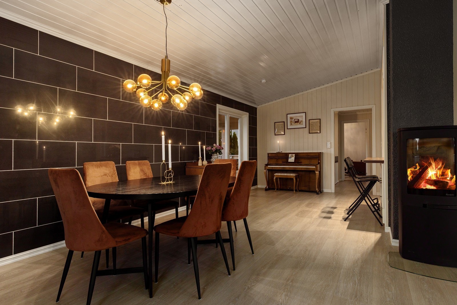 Rundt spisebordet fylles luften av latter og samtaler, med lyden av bestikk som klirrer mot tallerkenene i det varme, dempede lyset. Galleribilde