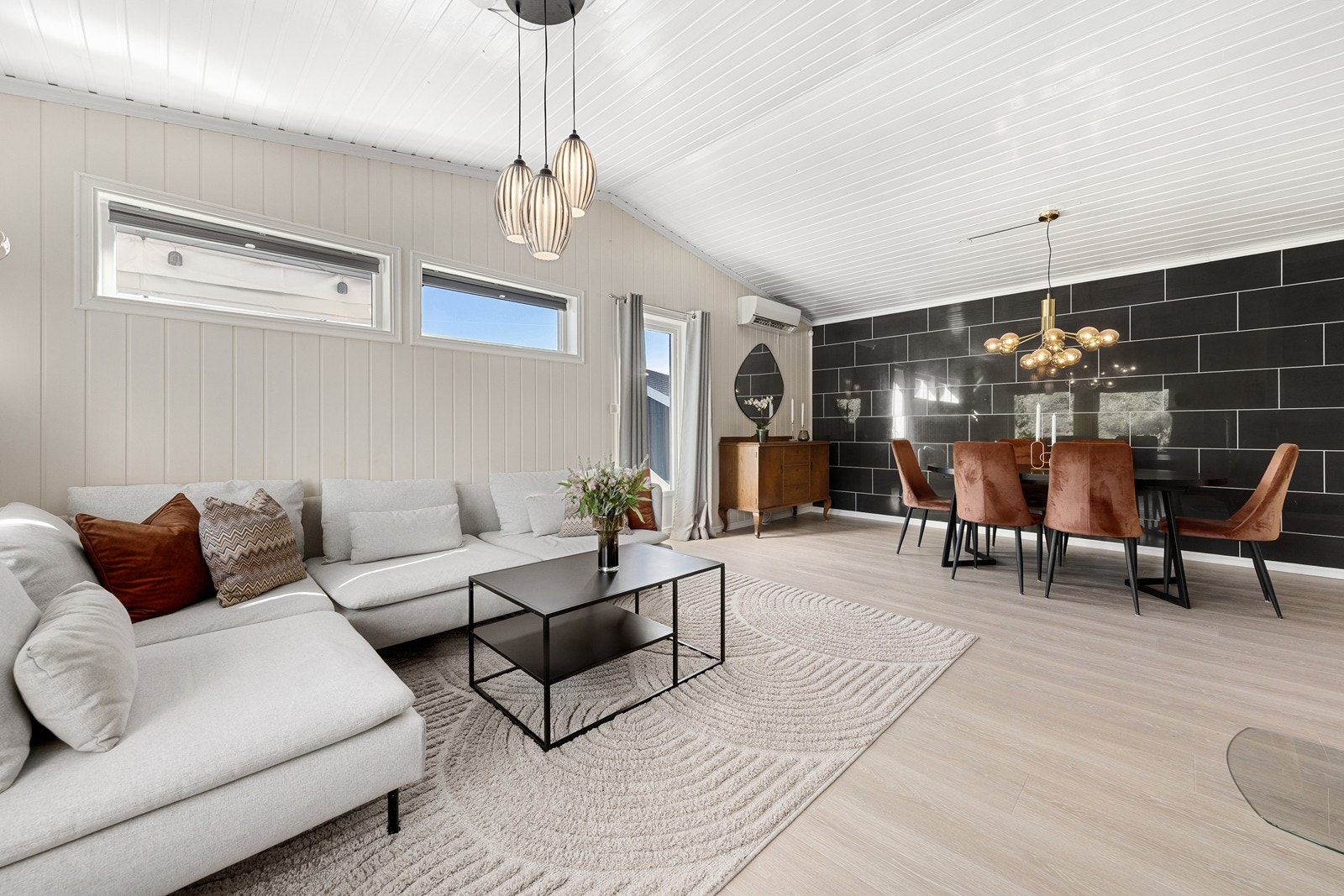 Stilren og innbydende stue i 1.etasje med 1-stavs laminat på gulv og panel vegger malt i en dus fargetone, som gir rommet en lun følelse. Galleribilde