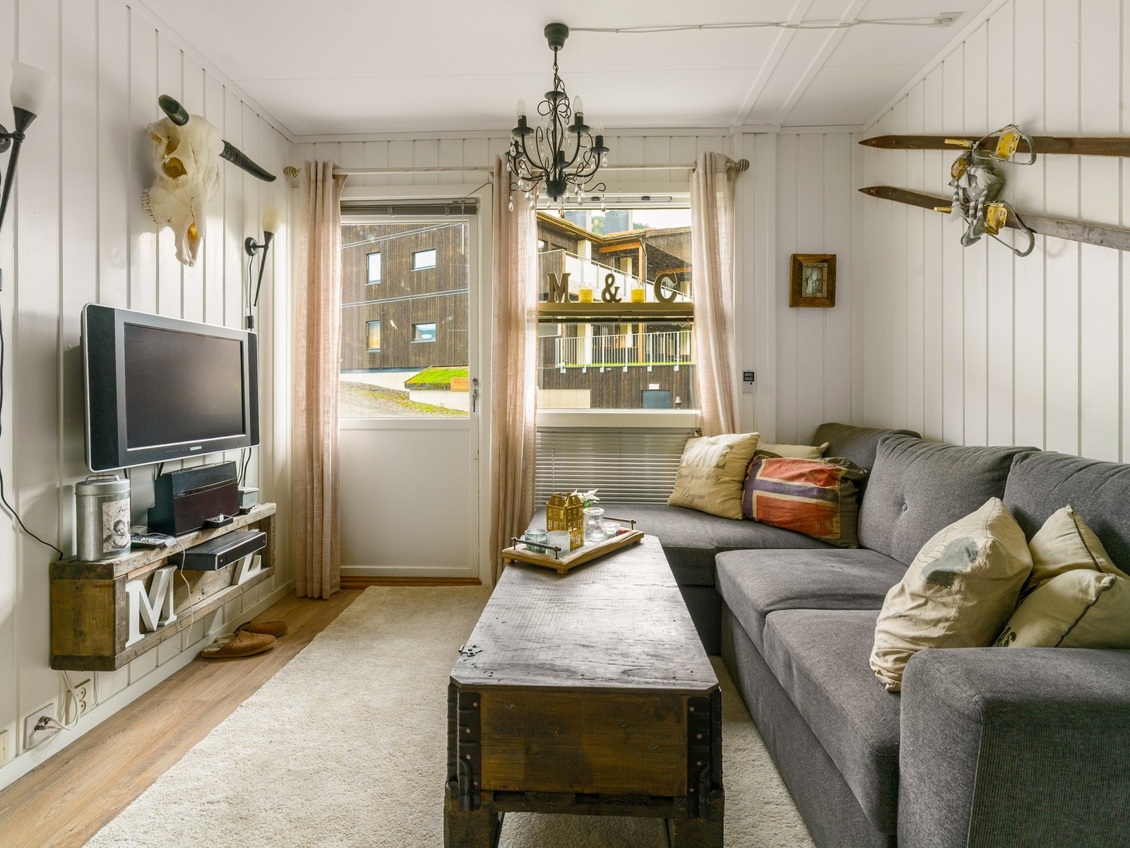 Lys stue med plass til sofa og tilhørende møblement. Galleribilde