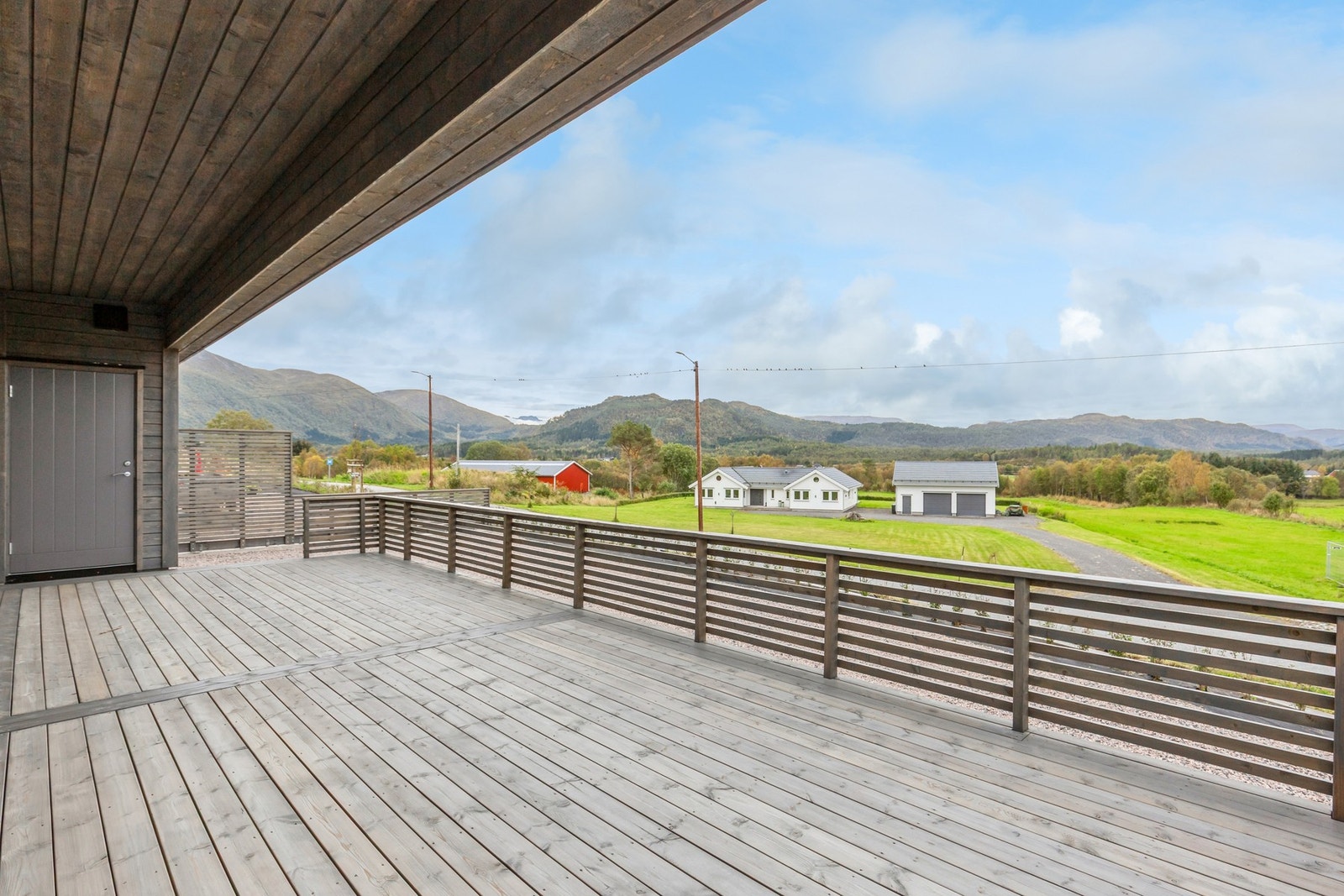 Det er tilgang til den sydvestvendte terrassen både fra stue/kjøkken og fra bod i bakkant av garasje Galleribilde