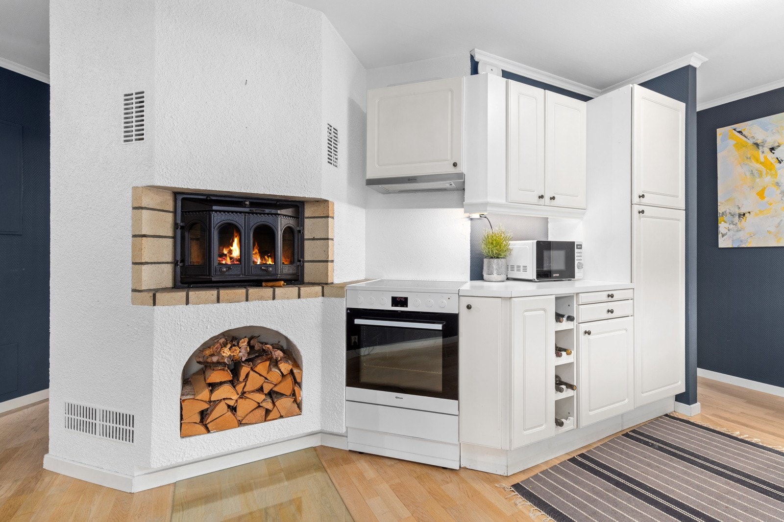 Kjøkkenet er også utstyrt med en koselig peis som byr på varme i hele leiligheten. Galleribilde