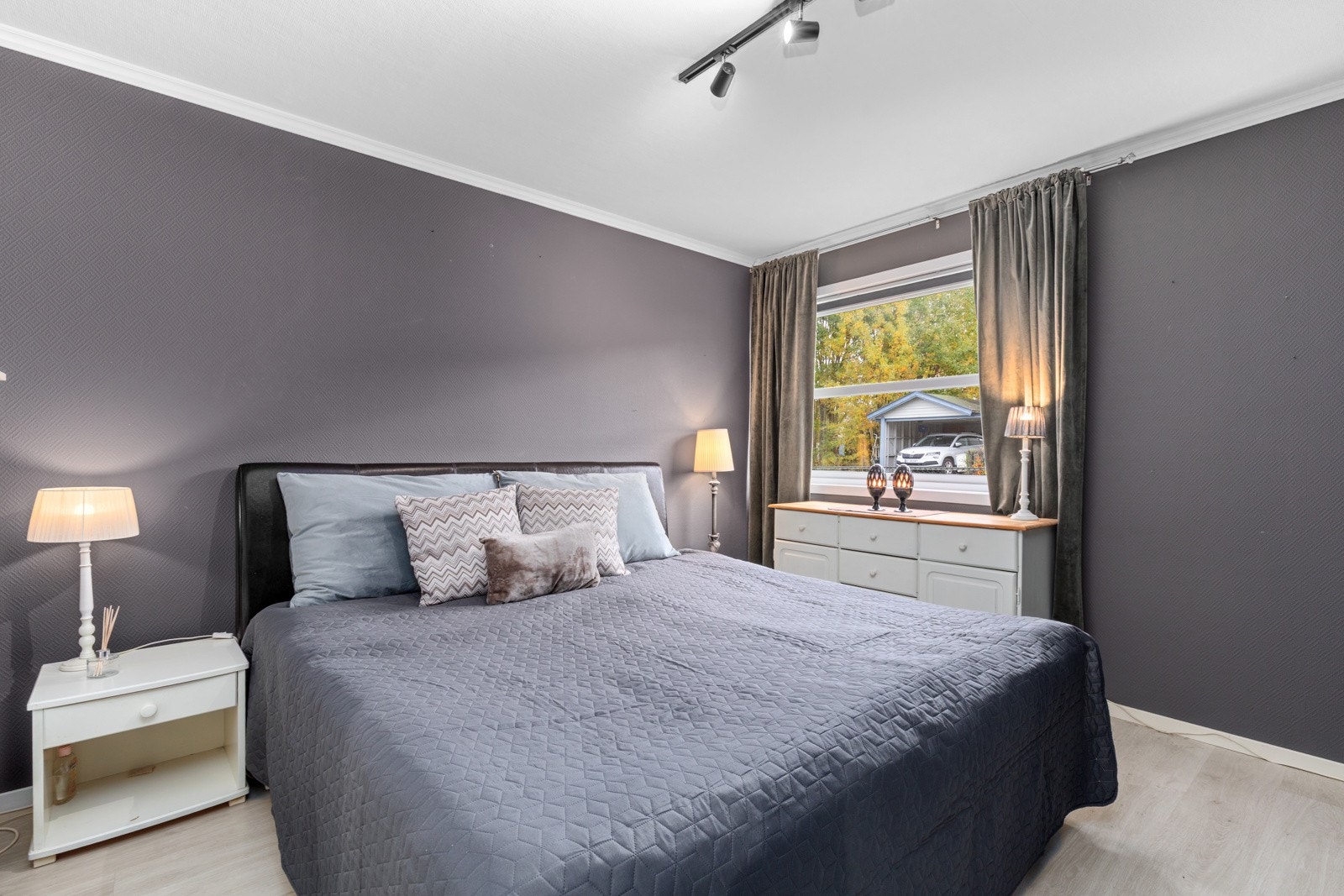 Boligens hovedsoverom er romslig og har god plass til en dobbeltseng, nattbord og tilhørende møblement. Galleribilde