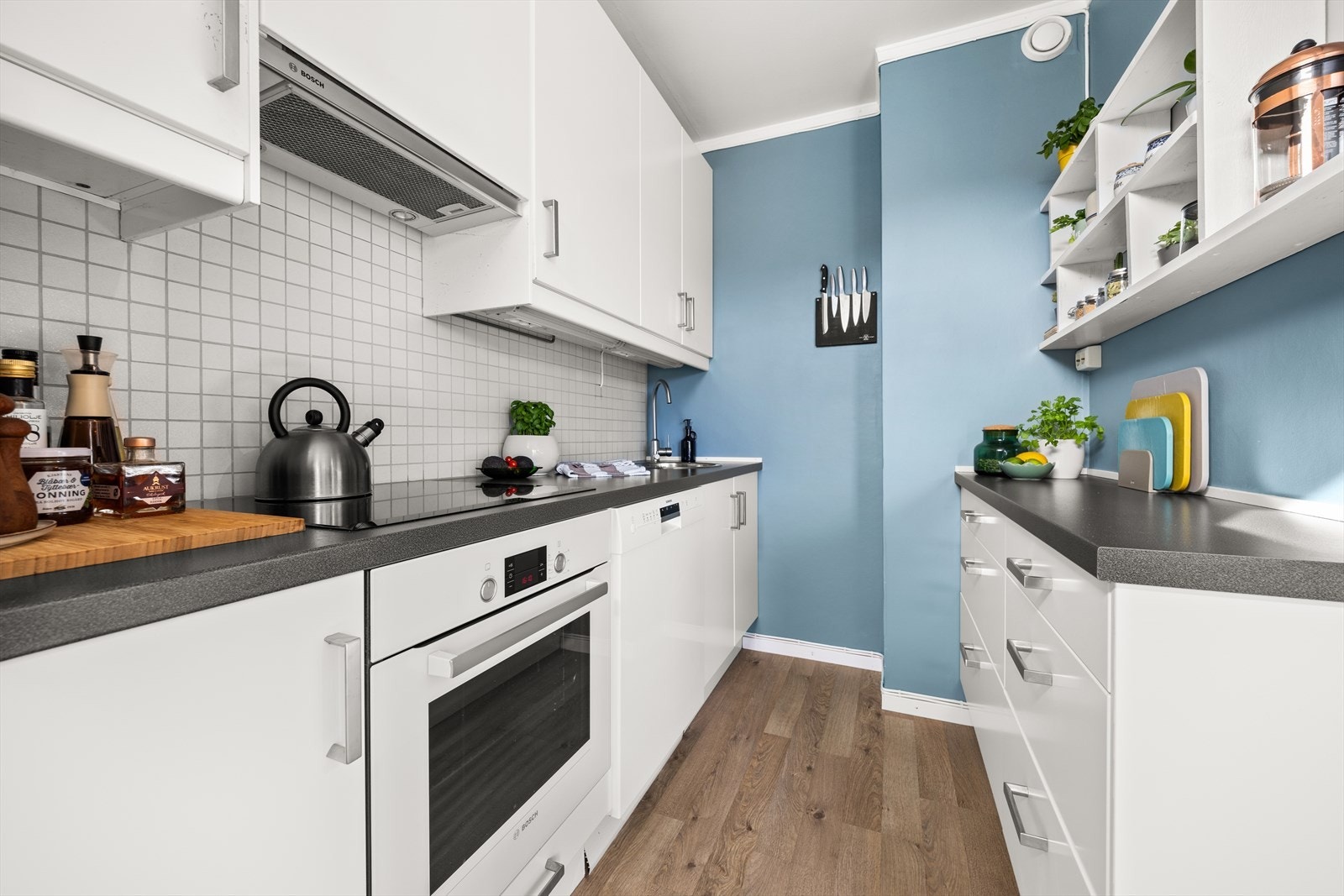 Kjøkkenet er smart innredet, og har godt med både skap- og benkeplass Galleribilde