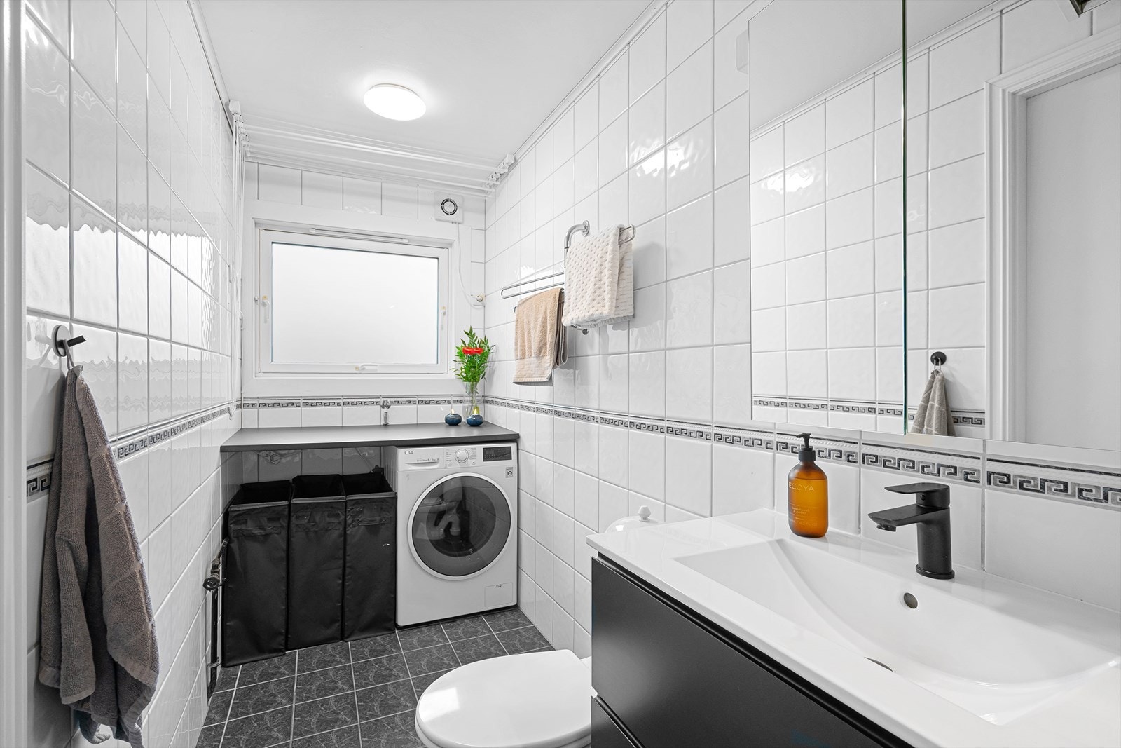 Praktisk løsning med vaskesone med plass til vaskemaskin og benk over. Galleribilde