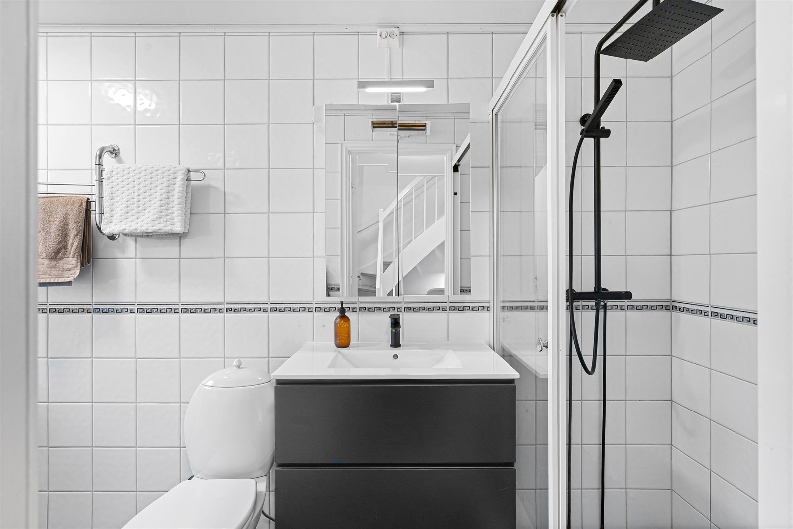 Stilrent bad med helflisede flater og moderne fargekombinasjon. Galleribilde