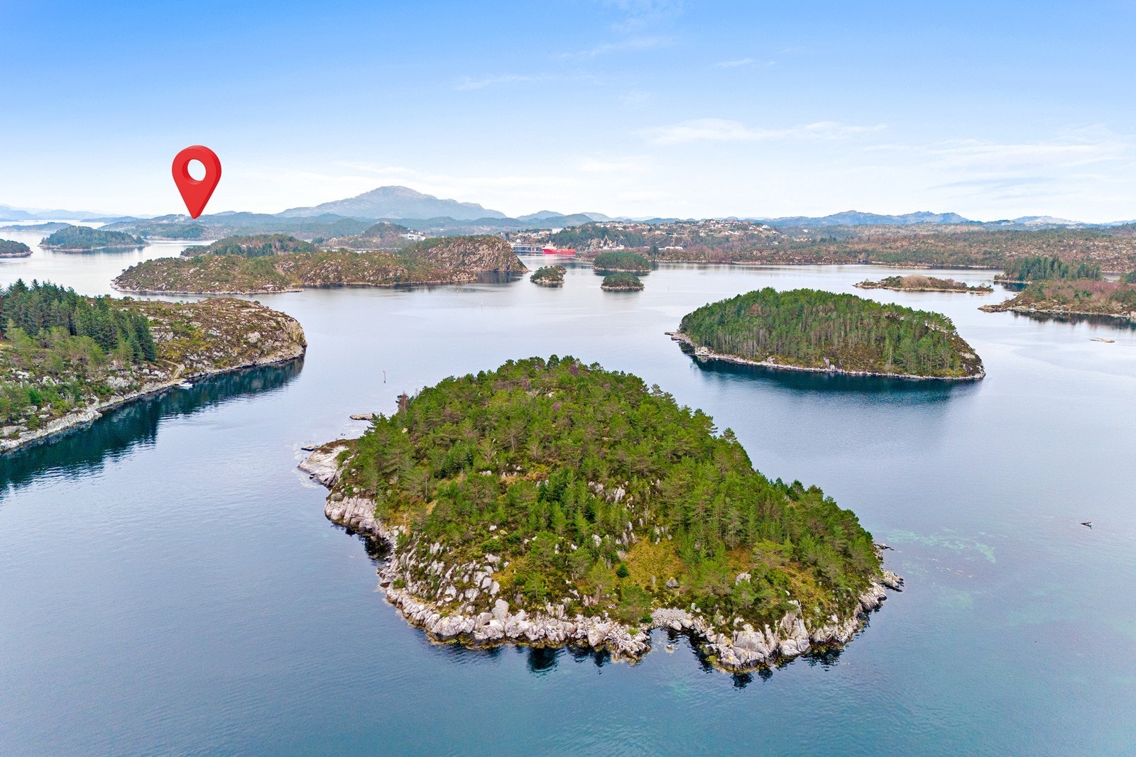 Litla Klakksøy i front, Stora Klakksøy til venstre og teig på fastlandet ved Juskenakken under rød pil. Galleribilde