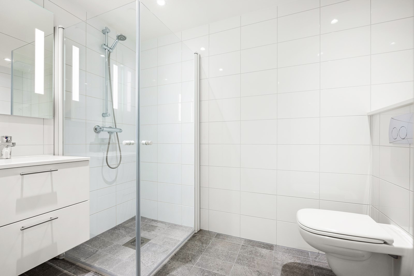 Servant i innredningen, dusjhjørne og vegghengt toalett. Galleribilde