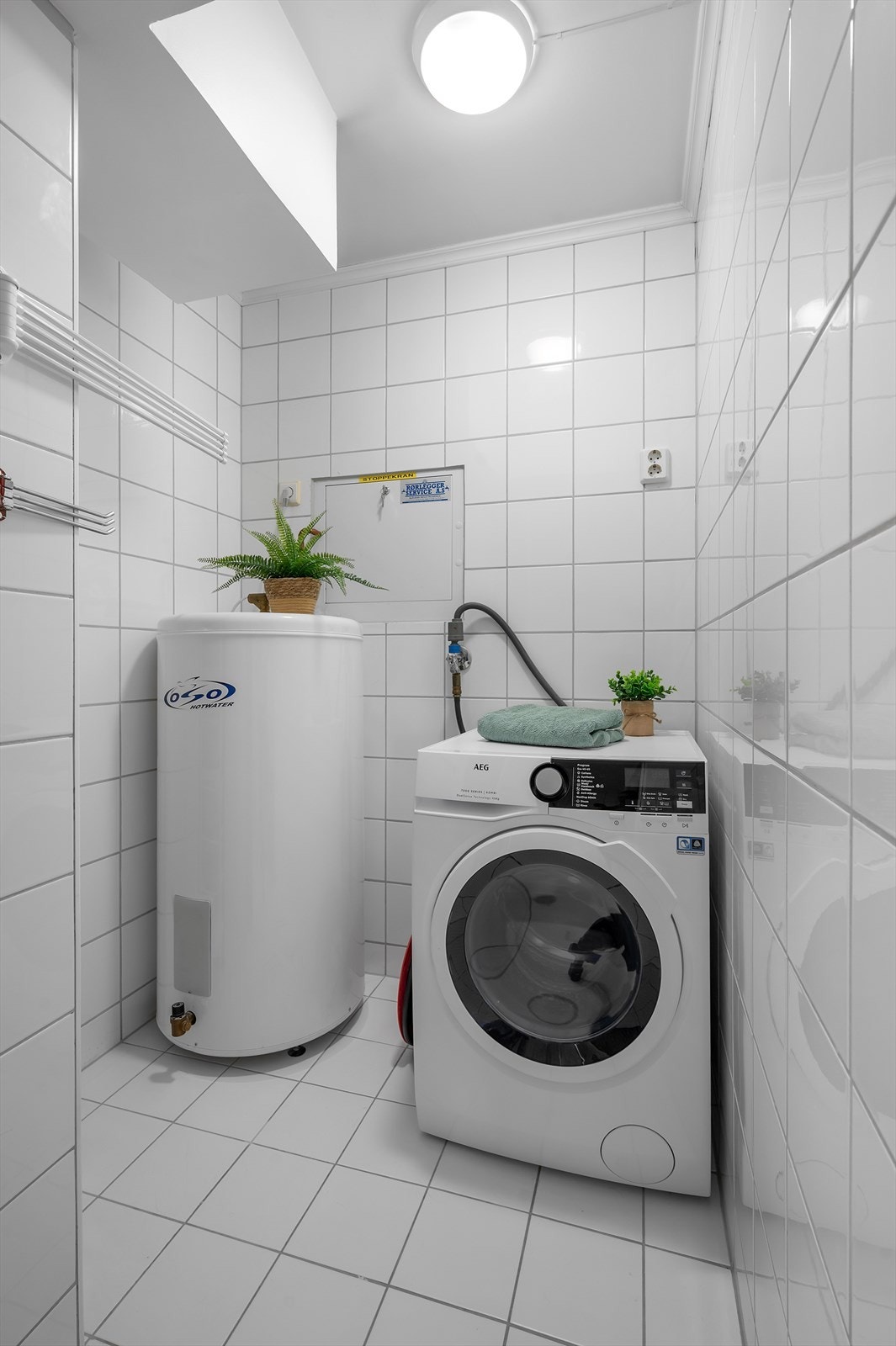 Praktisk vaskeromsløsning gjemt bak skyvedører på badet Galleribilde