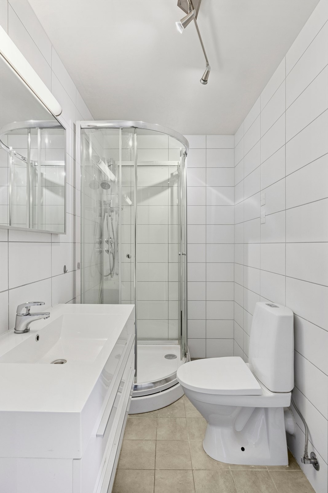 Badet har flislagte overflater - Her finner du toalett, dusjkabinett, opplegg for vaskemaskin og baderomsinnredning. Galleribilde