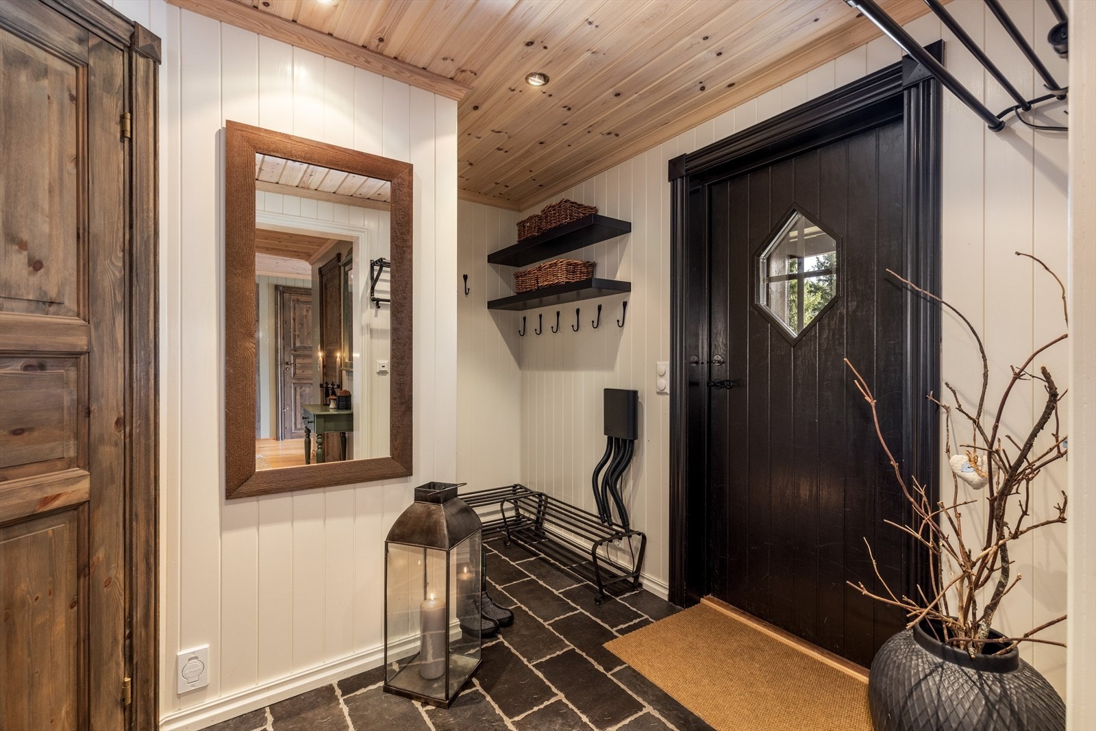 Hytta har lyse, innbydende gangarealer hvor det i vindfanget er flislagt gulv. Her er det etablert en liten nisje med god plass til sko- og ytterklær. Galleribilde