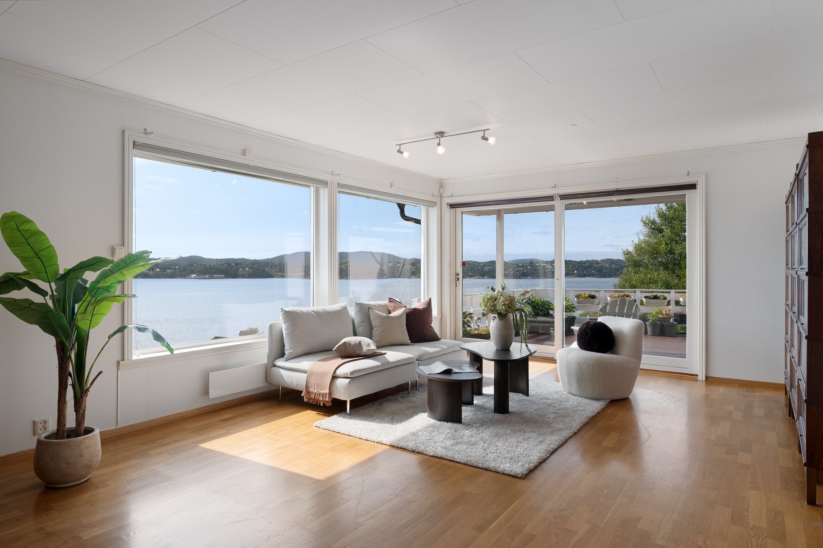 Stue med store vinduer mot sjøutsikten, utgang til terrasse. Galleribilde