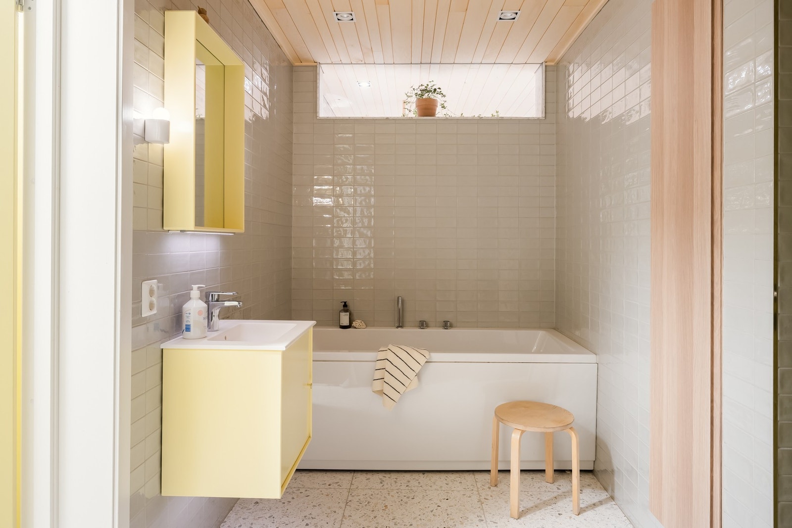 Gjennomførte materialer og innebygd skap skaper ryddig inntrykk. Glassvindu over badekar gir siktlinje inn til det andre badet og god romfølelse. Galleribilde