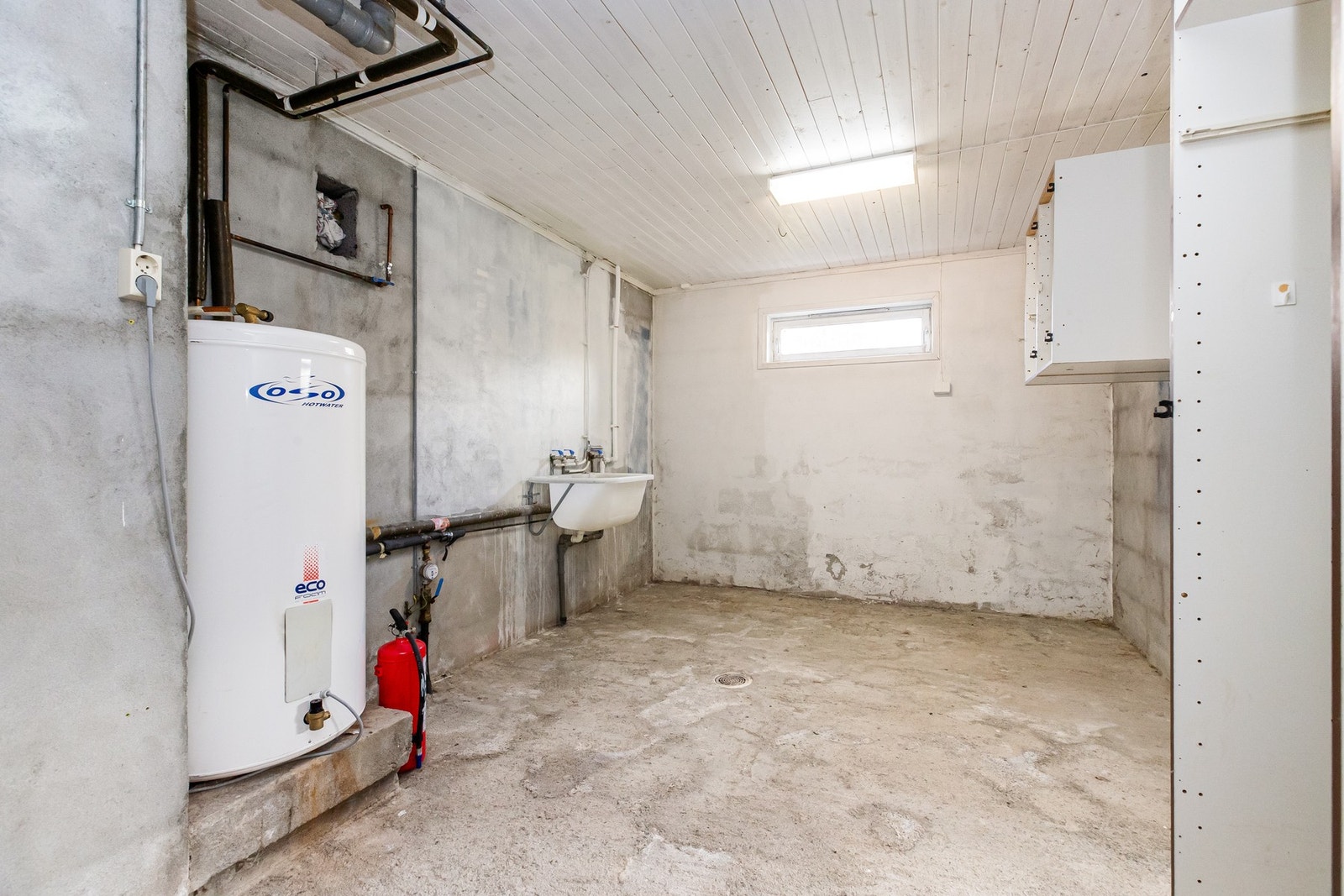 I kjeller er det også kjellerrom med tekniske installasjoner. Her er varmtvannsbereder lokalisert, og her finnes også utslagsvask. Sluk i gulv. Galleribilde