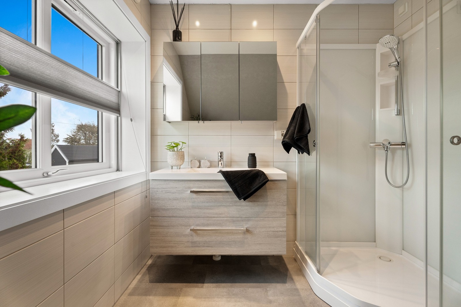 Innredning er med skuffeseksjon, speilfronter på overskap, dusjkabinett og gulvstående toalett Galleribilde