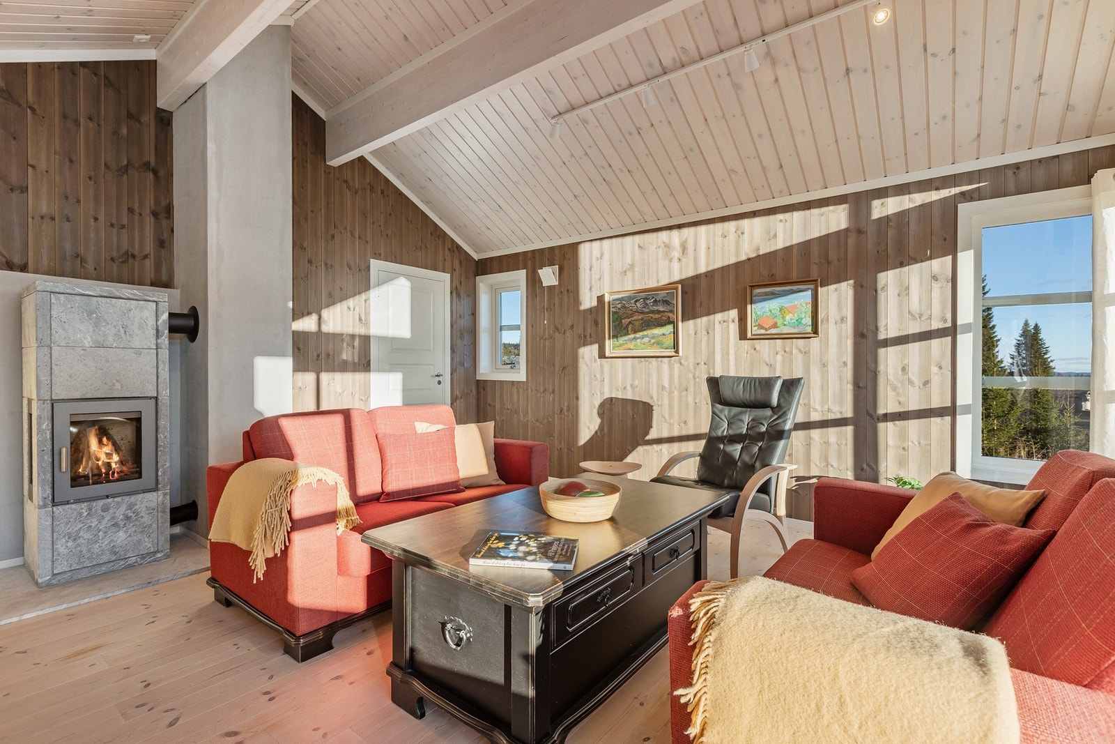 De lyse furugulvene og panelte veggene gir en varm og hyggelig atmosfære, mens de store vinduene slipper inn rikelig med dagslys og utsikten er nydelig. Galleribilde