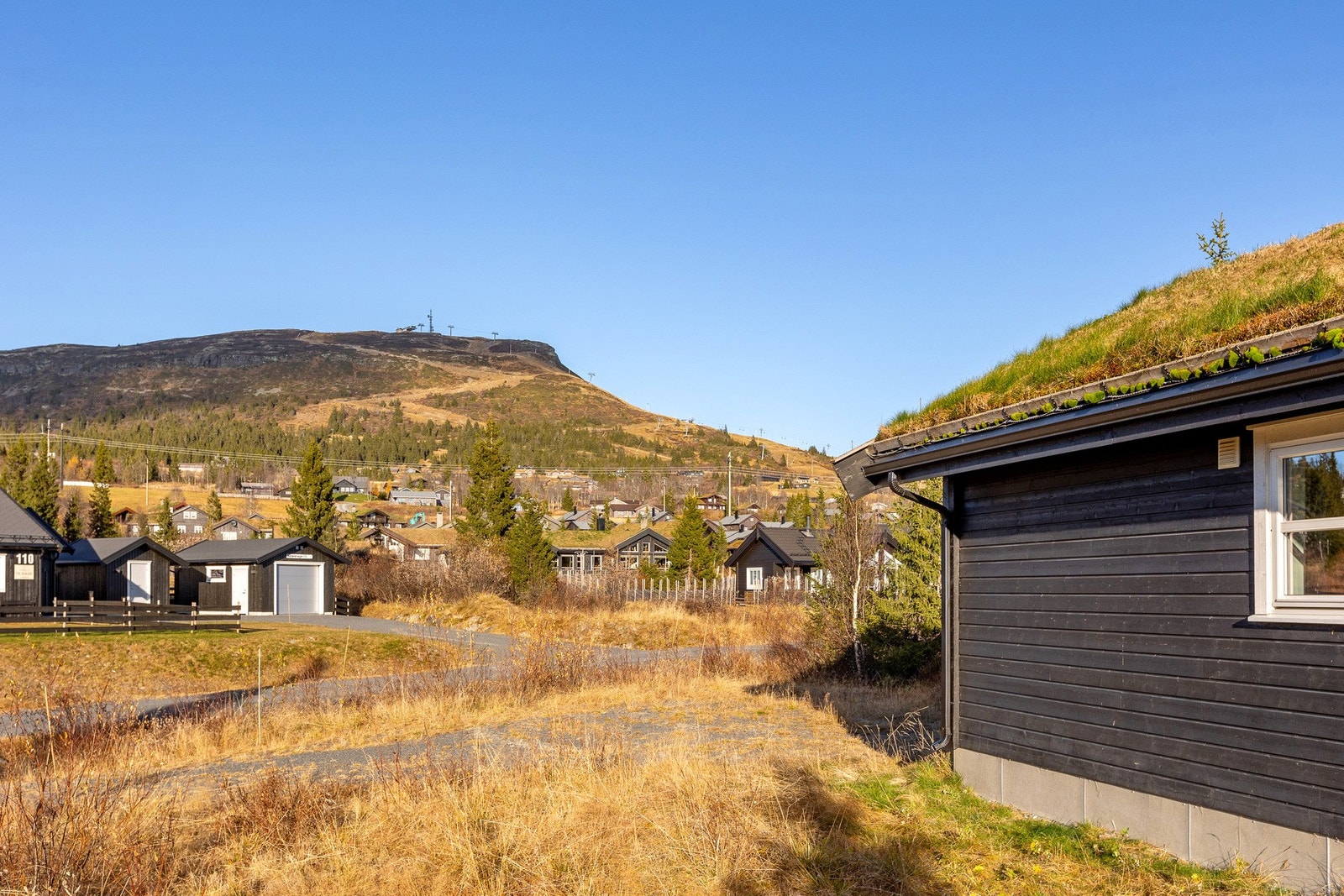 Beliggenheten gir en fin kombinasjon av åpenhet og skjerming, med naturlig omkransing av terrenget og trær som gir privatliv. Galleribilde