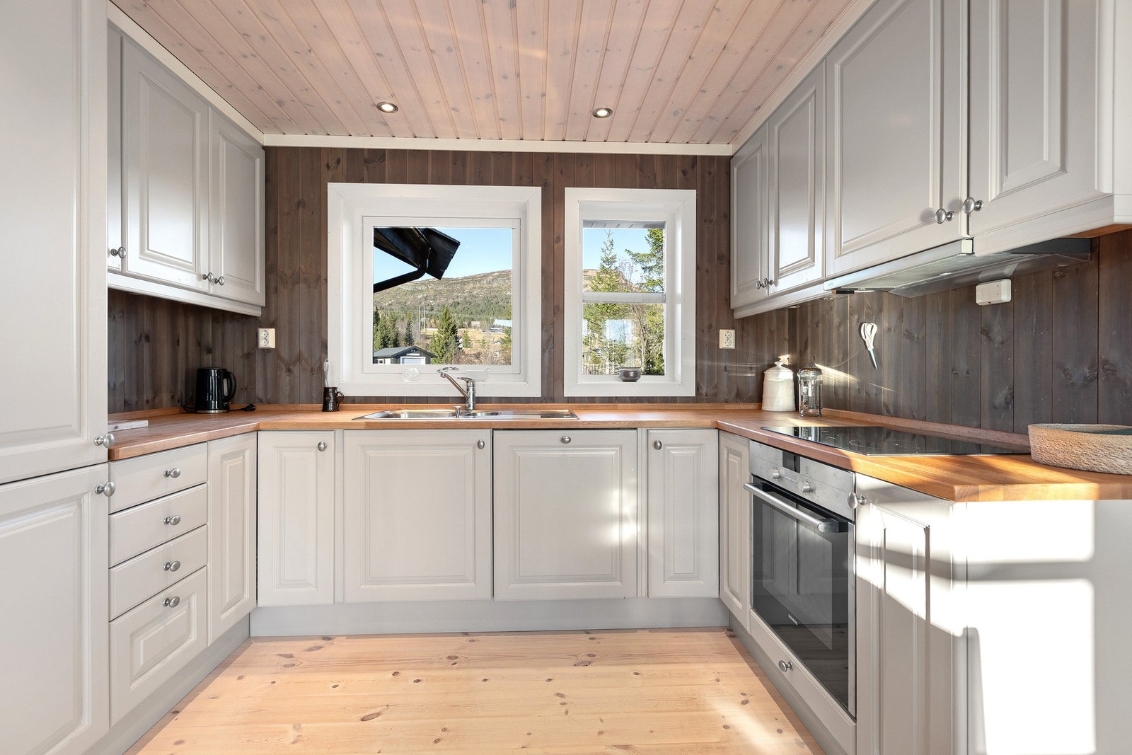 Hytta har et pent og funksjonelt kjøkken med innredning med profilerte fronter og heltre benkeplate. Galleribilde