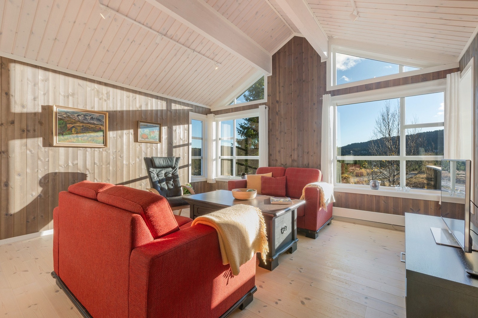 Den trivelige stua har god takhøyde, store vindusflater og flott utsyn mot naturen. Galleribilde