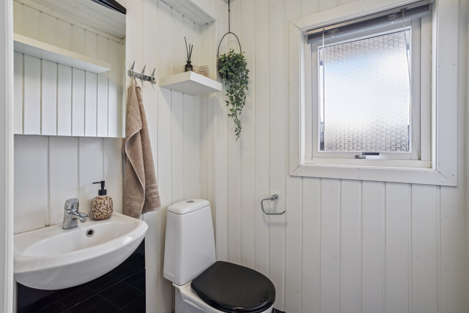 Praktisk med bad i 1. etasje også. Dette er et eldre bad med WC, dusjkabinett, servant med underskap og overskap Galleribilde