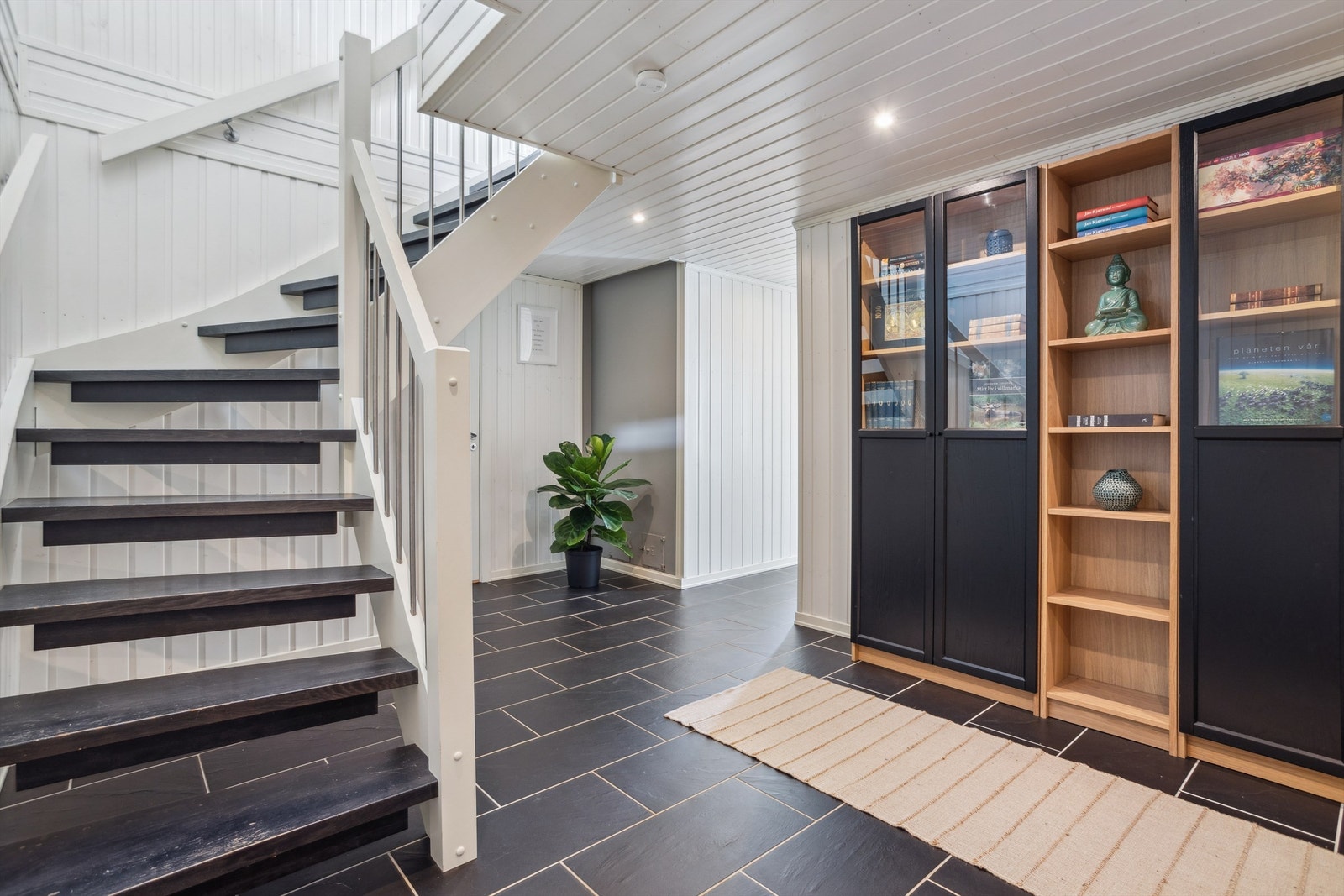 Trapperom/hall i sokkeletasjen. Alle rom i sokkeletasjen har varmekabler i gulv (unntatt bod og kinorom). Downlights i himling i alle rom i sokkeletasje med unntak av stue og kinorom Galleribilde