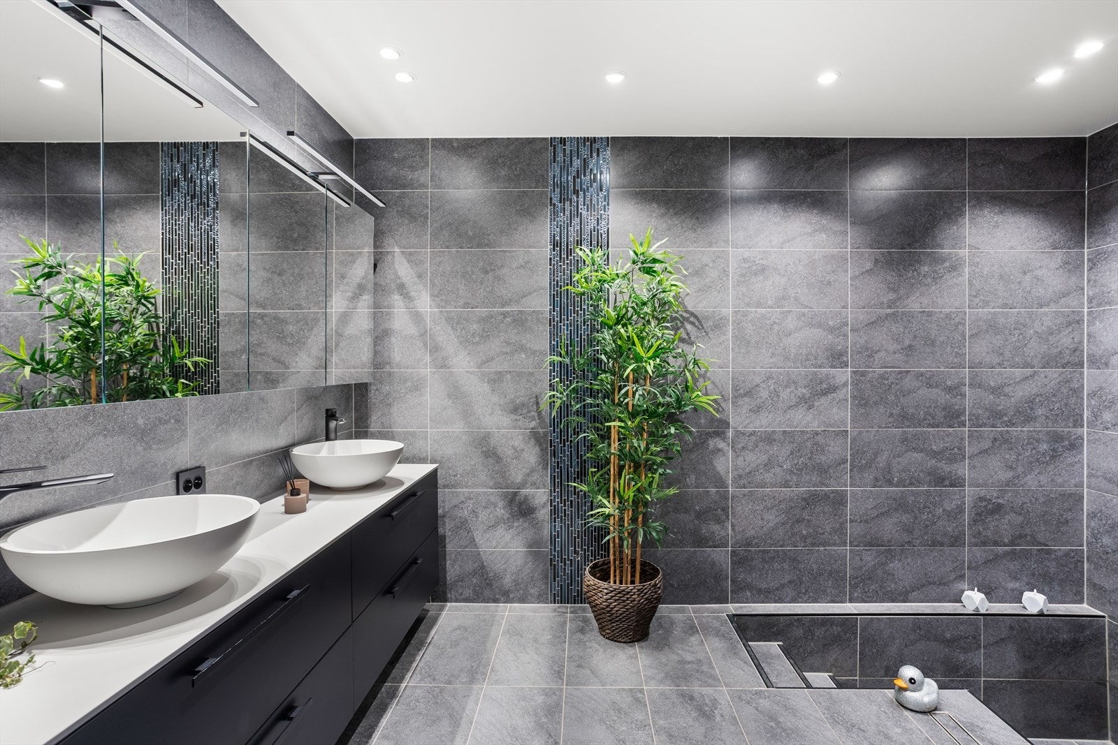 Badet er innredet med servantskap med servanter, speilskap med belysning og vegghengt toalett. Galleribilde